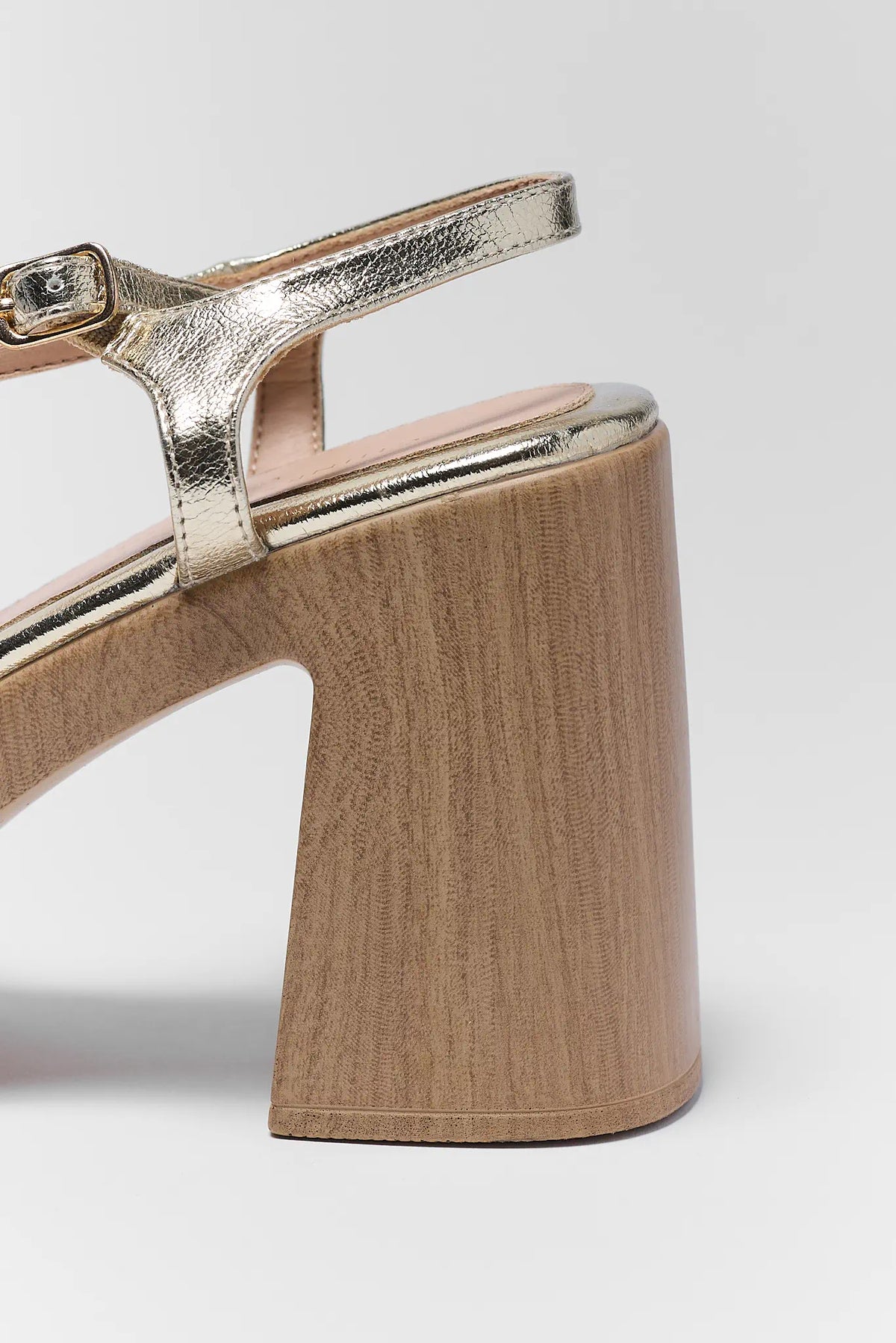 Gold metallic ankle strap and wood-grain block heel close-up detail | Avara