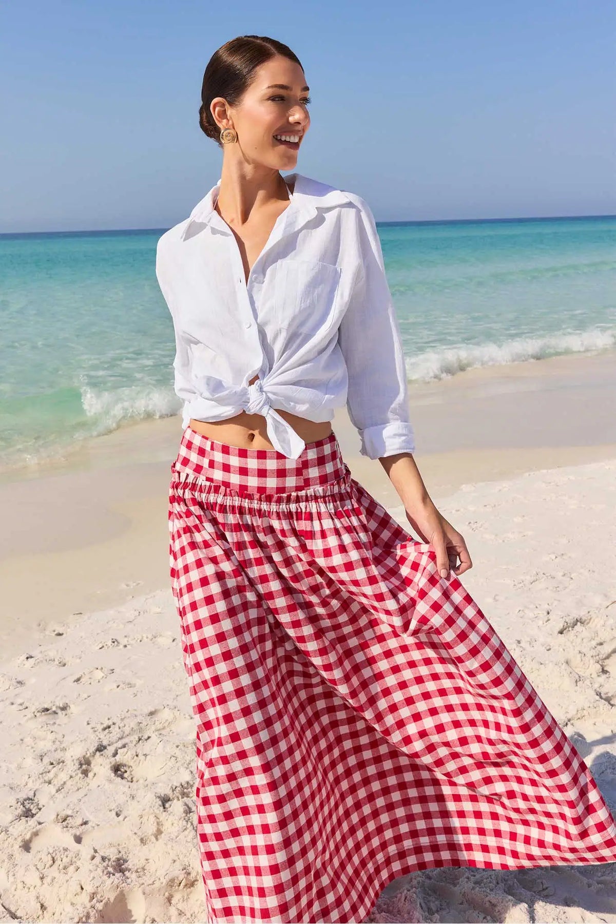 Allie Red Gingham Maxi Skirt styled with knotted white shirt on beach - Vacation Lifestyle | Avara