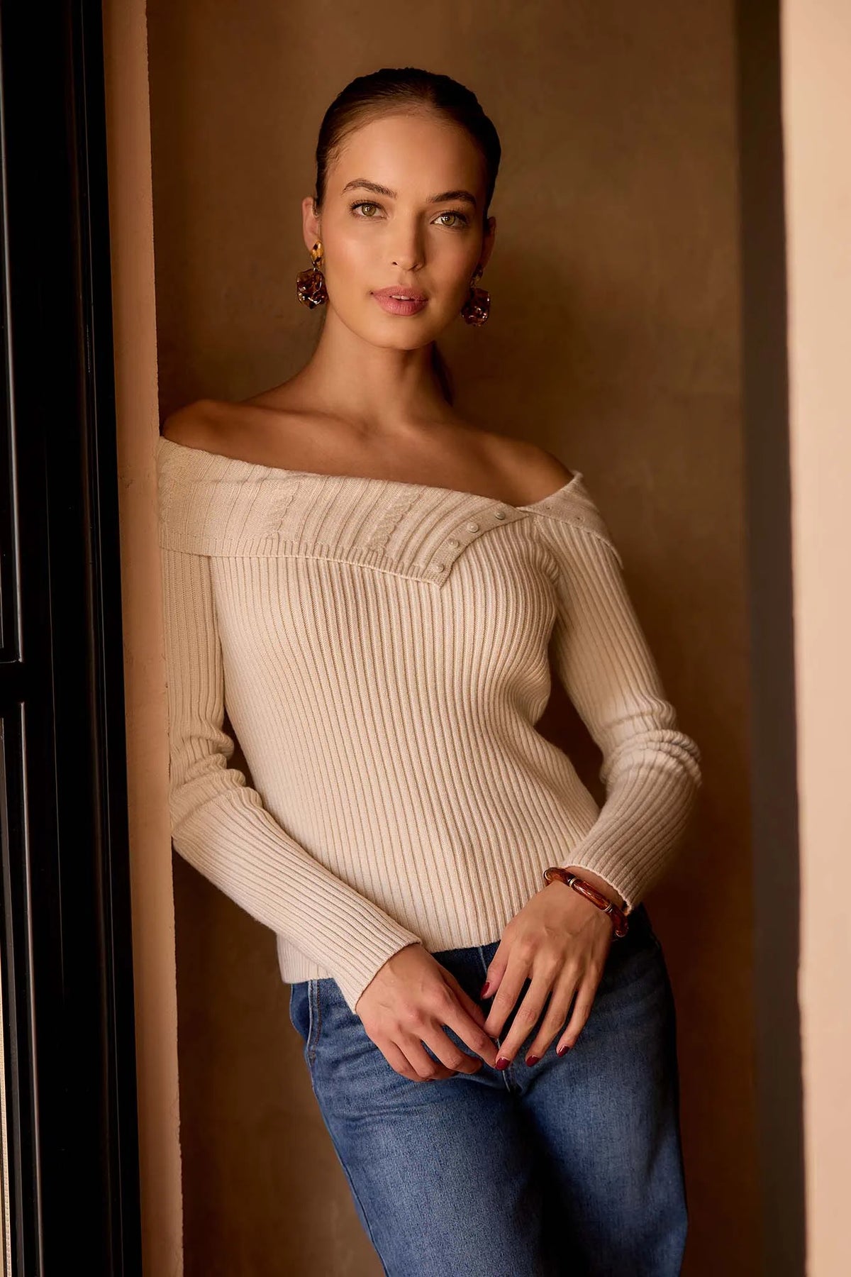 Ashlyn Ribbed Knit Top cream off-shoulder fitted sweater with button detail, styled with jeans - Lifestyle Front | Avara