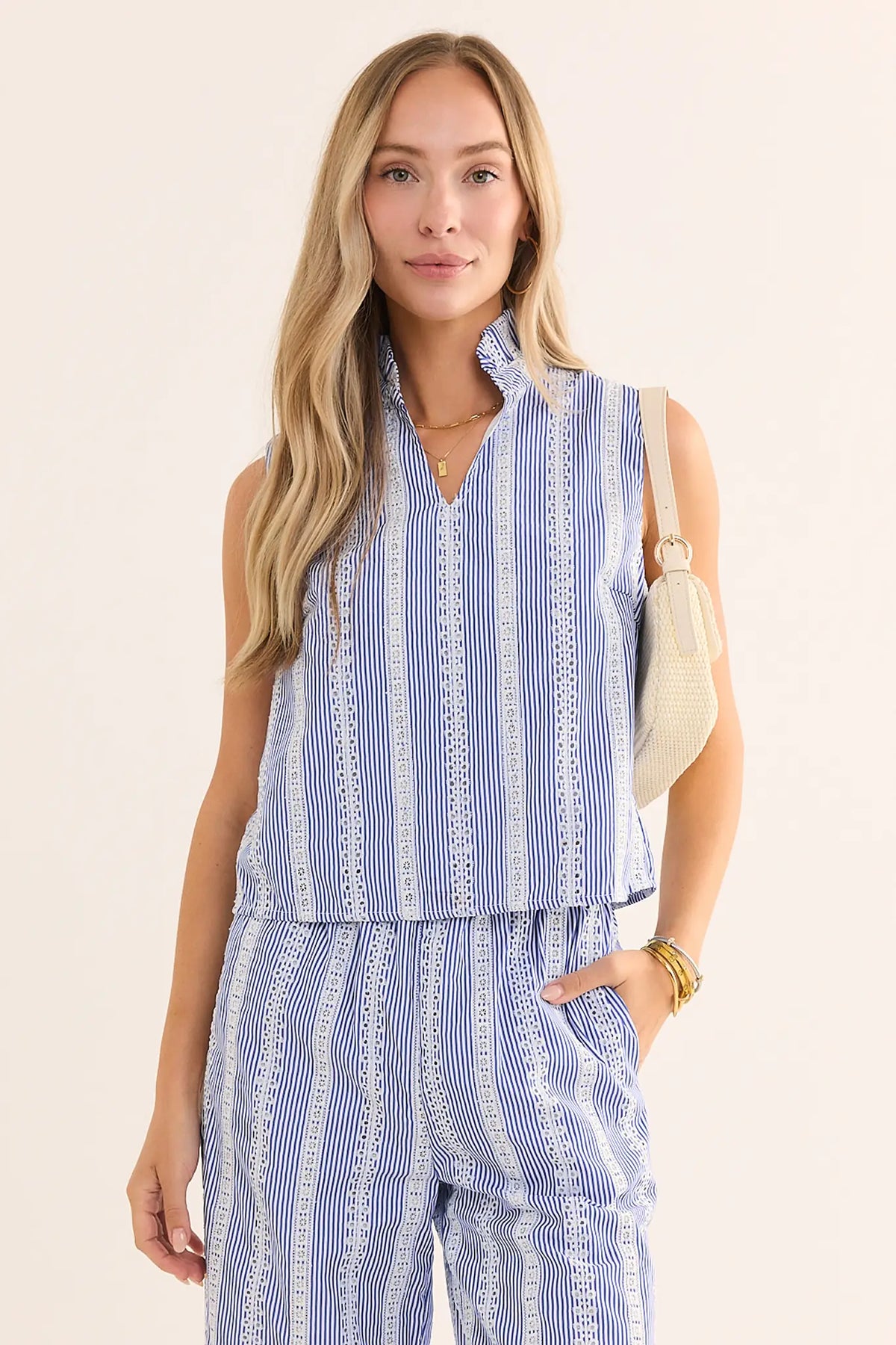 Woman wearing blue stripe embroidered tank top with matching wide-leg pants and cream bag - Front View | Avara