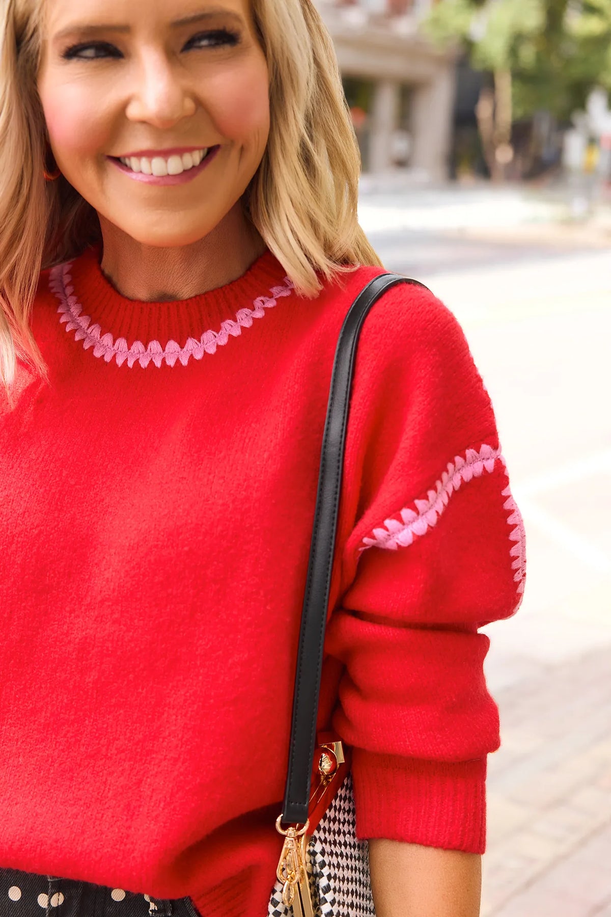 Red Knit Sweater with Pink Stitched Trim - Close-Up Neckline Detail | Avara