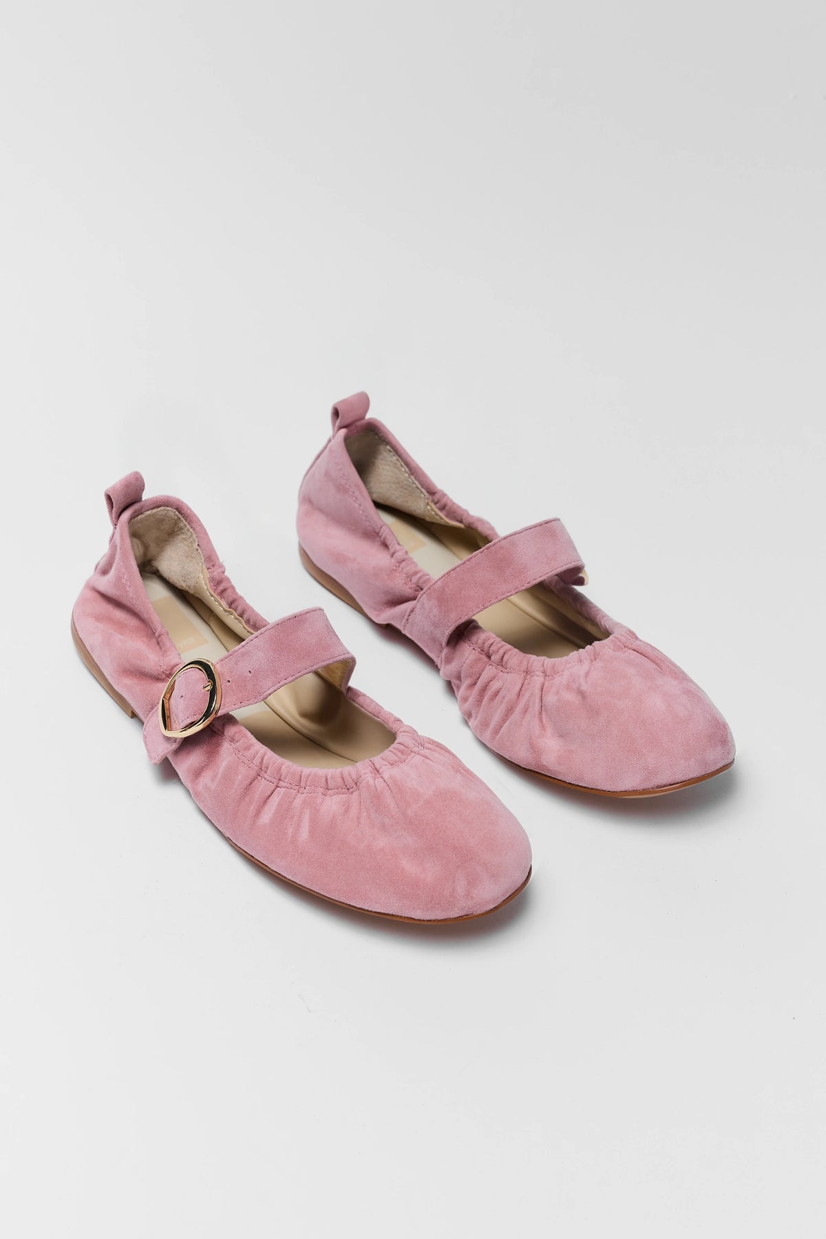 Pair of pink suede Dolce Vita ballet flats with gold buckle - Angled View | Avara