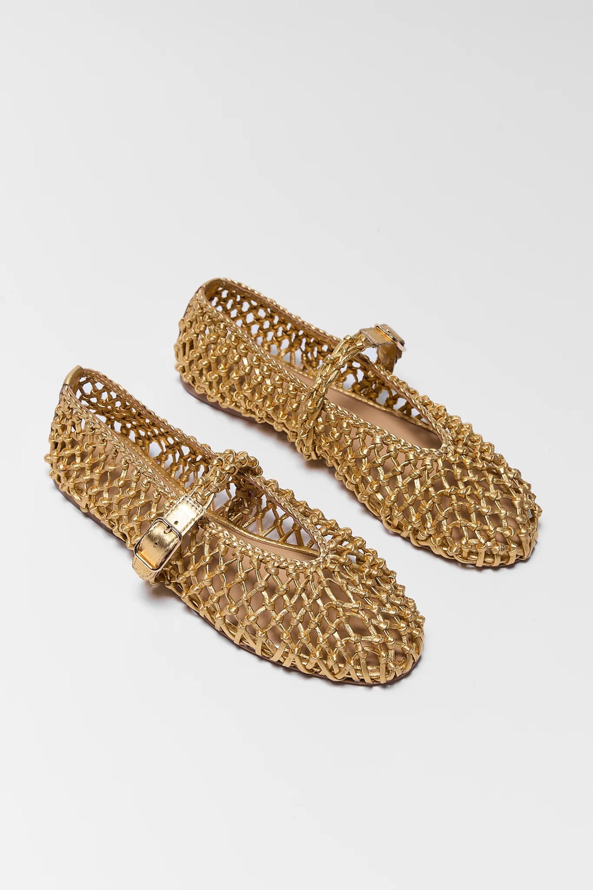 Pair of gold Dolce Vita woven leather flats with buckle strap - Angled View | Avara