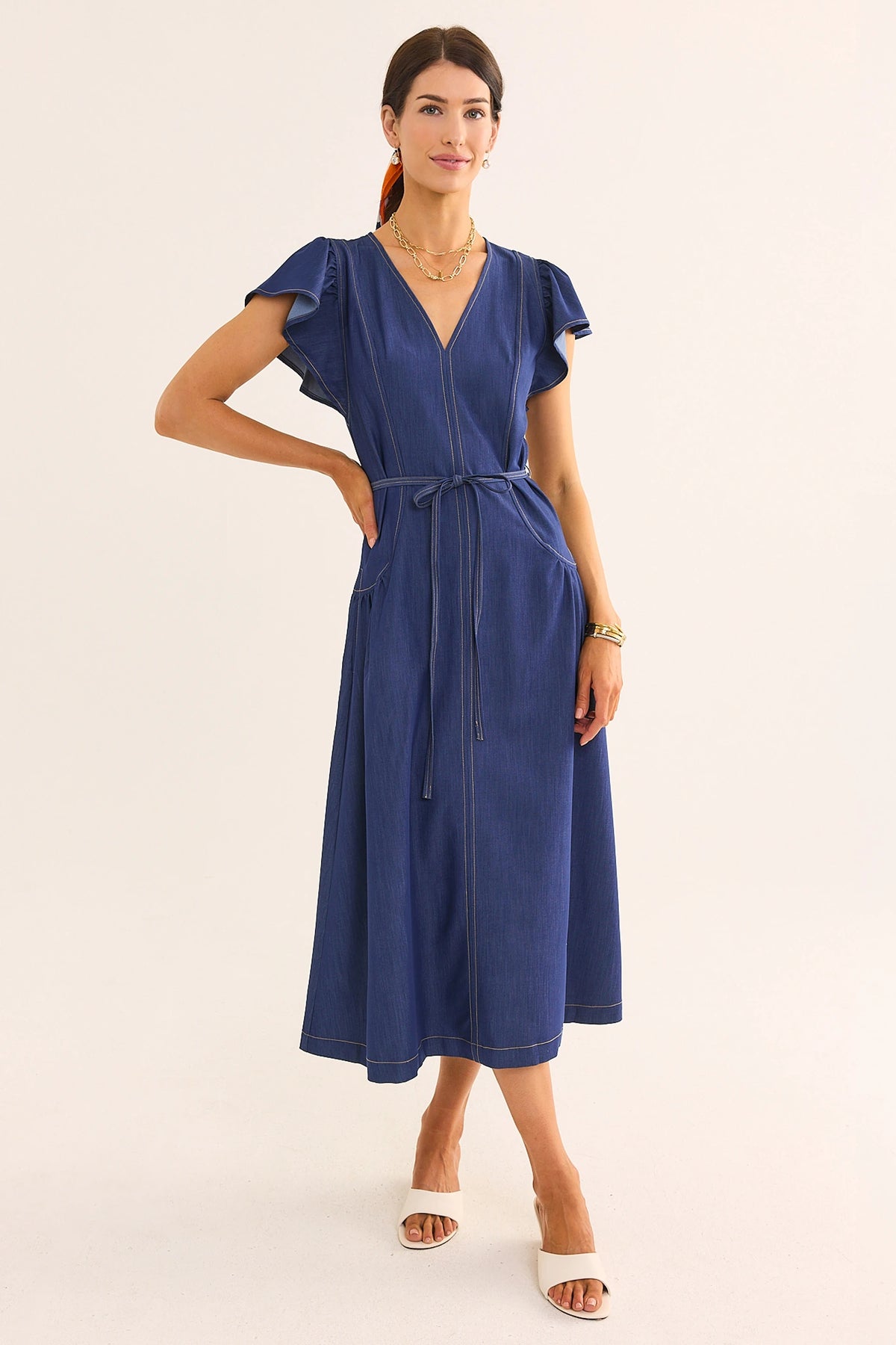Women's blue denim flutter sleeve midi dress with V-neckline, tie waist, and side pockets - Front View | Avara