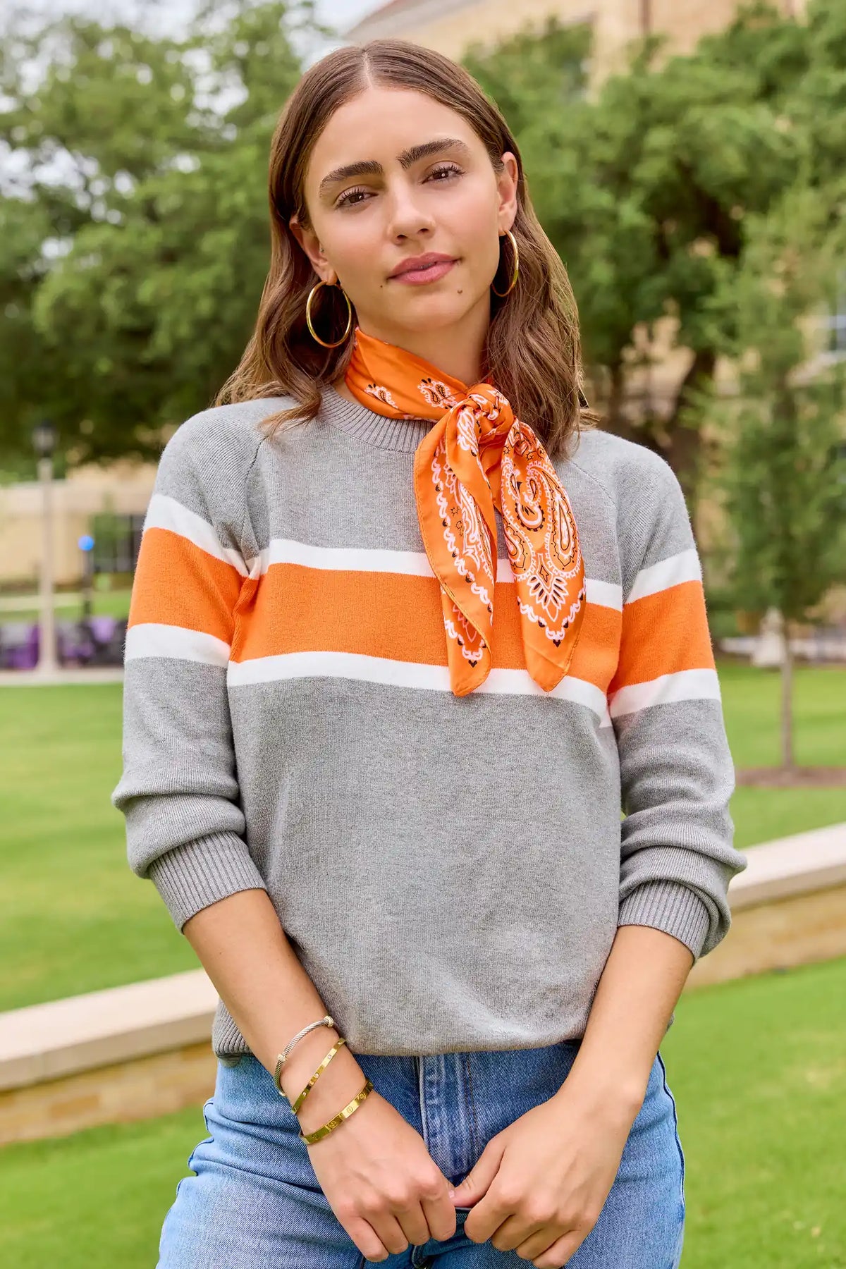 Dylan Orange Stripe Sweater styled with jeans and paisley neck scarf outdoors - Game Day Look | Avara