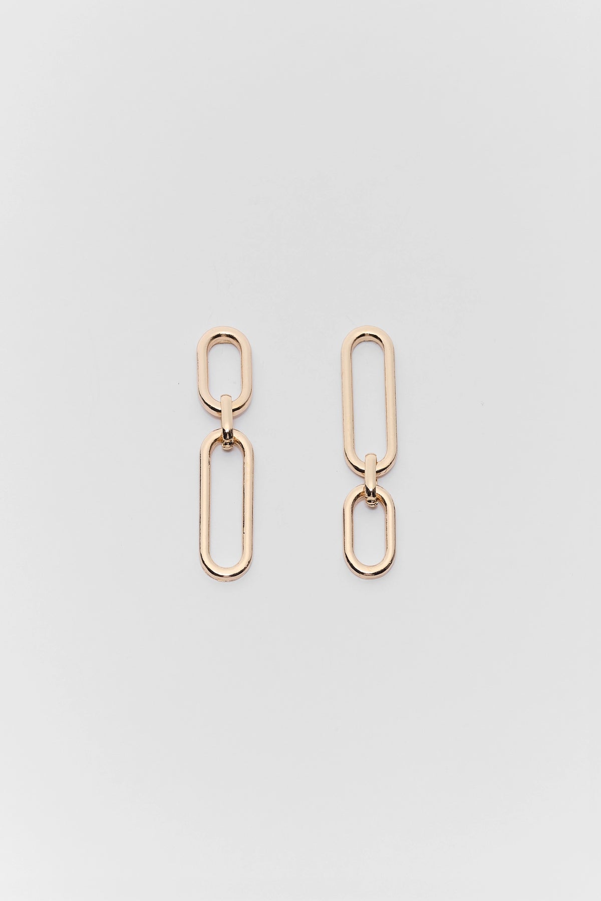 Gold chain link earrings on a light gray background