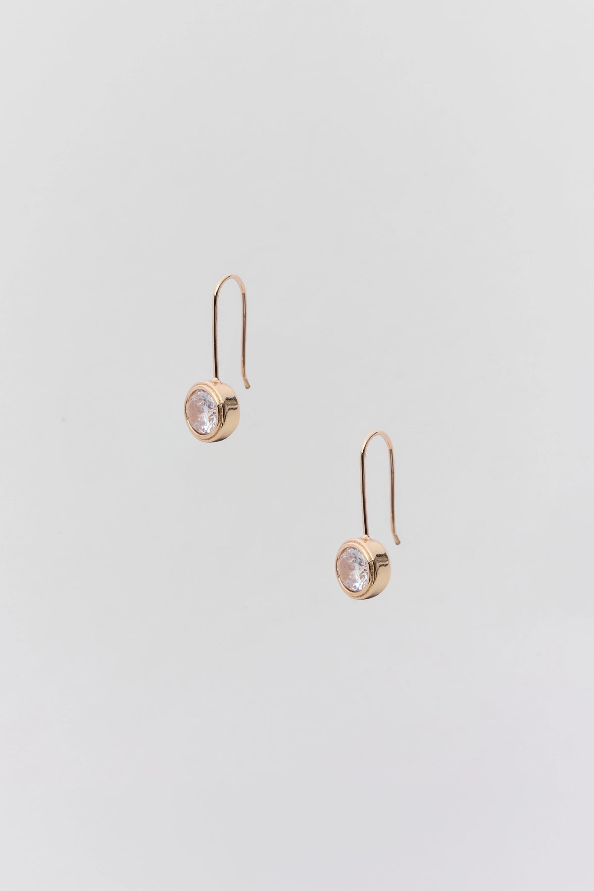 Gold Circle Rhinestone Drop Earrings with bezel-set clear stone, wire hook - Flat Lay | Avara