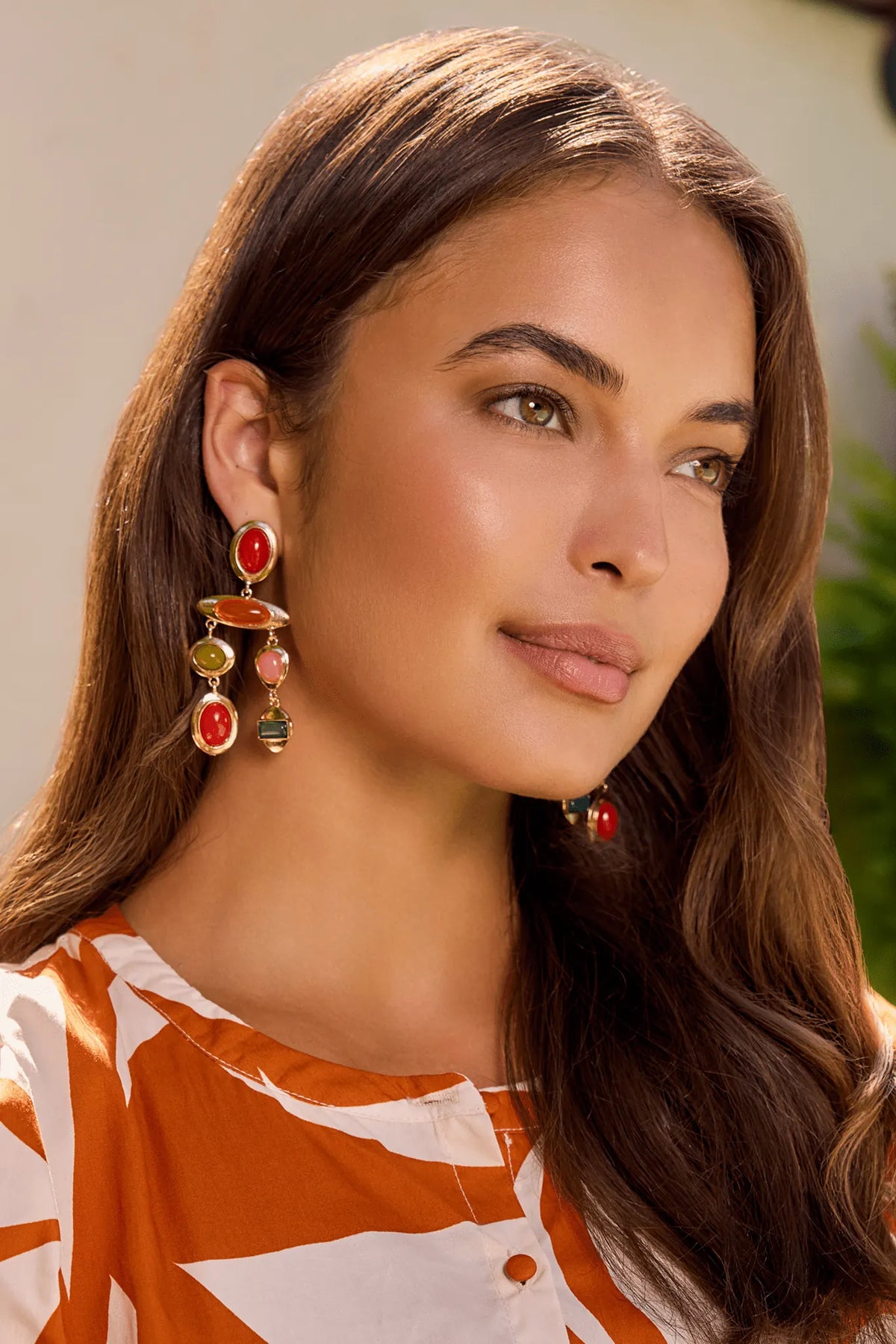 Woman wearing gold mixed stone drop earrings with red, orange, pink, and green stones - On Model Close-Up | Avara
