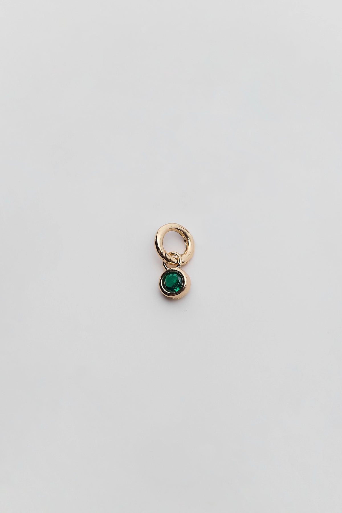 Green Rhinestone Charm with gold bezel setting and ring clasp - Flat Lay | Avara