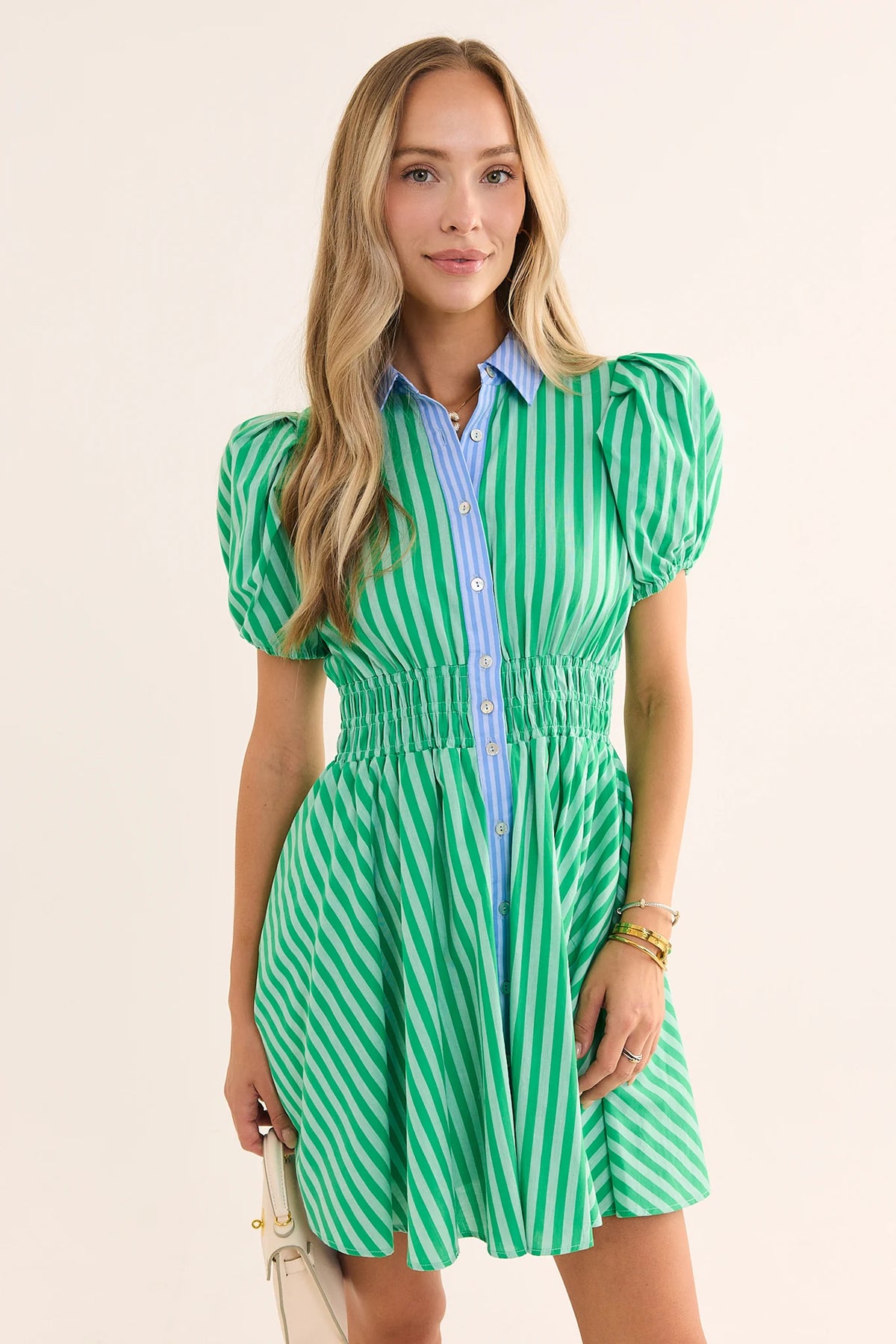 Woman in green striped button-up short dress with contrast blue collar, puff sleeves, smocked waist - Front View | Avara