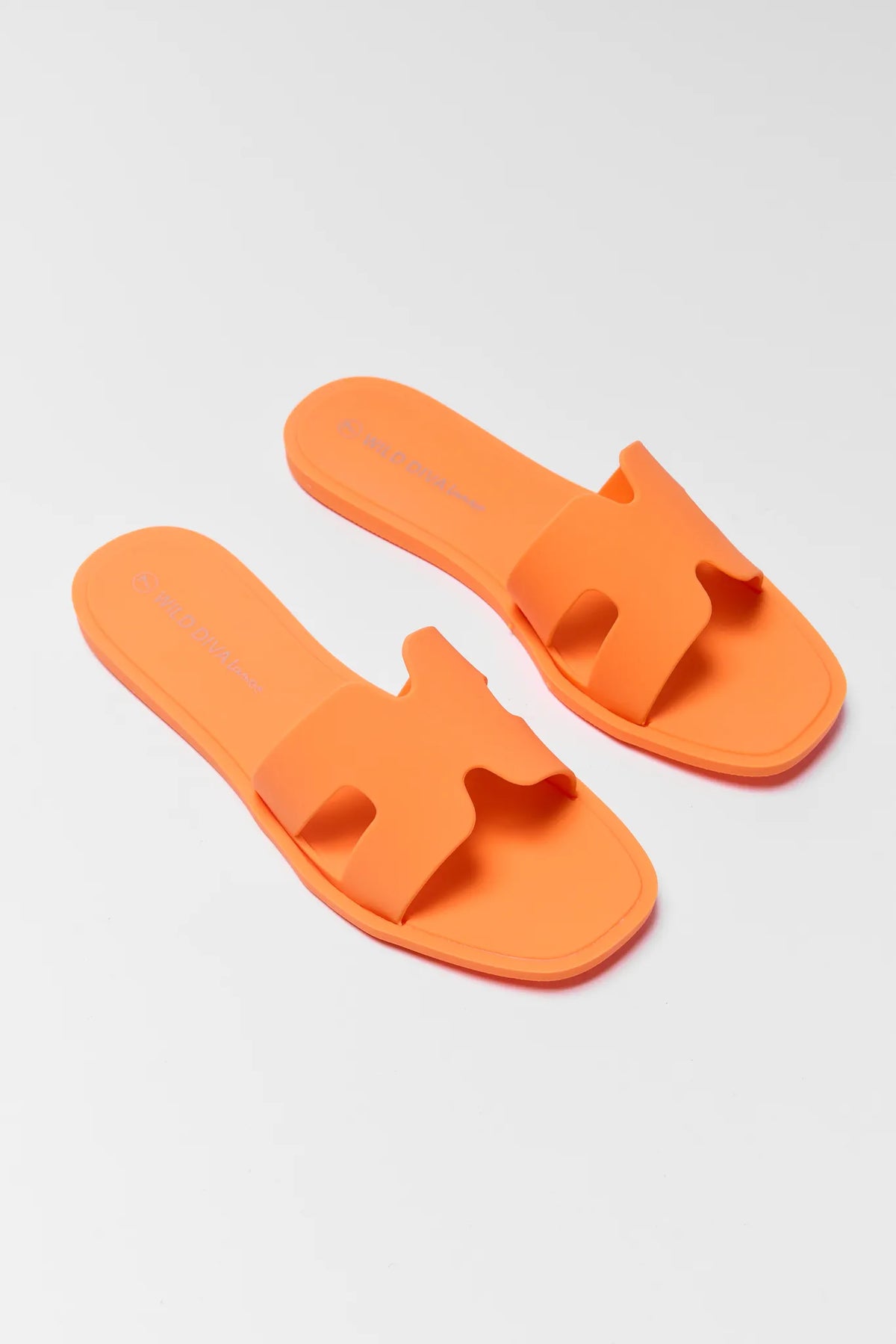 Orange jelly slip-on sandals with square toe, overhead flat lay view | Avara