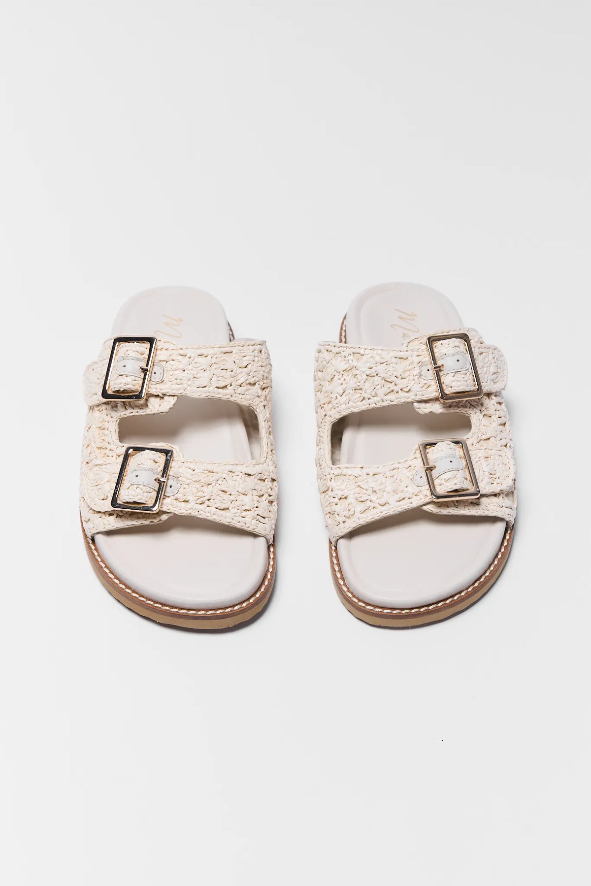 Tan woven raffia double-buckle sandals, pair flat lay top view | Avara