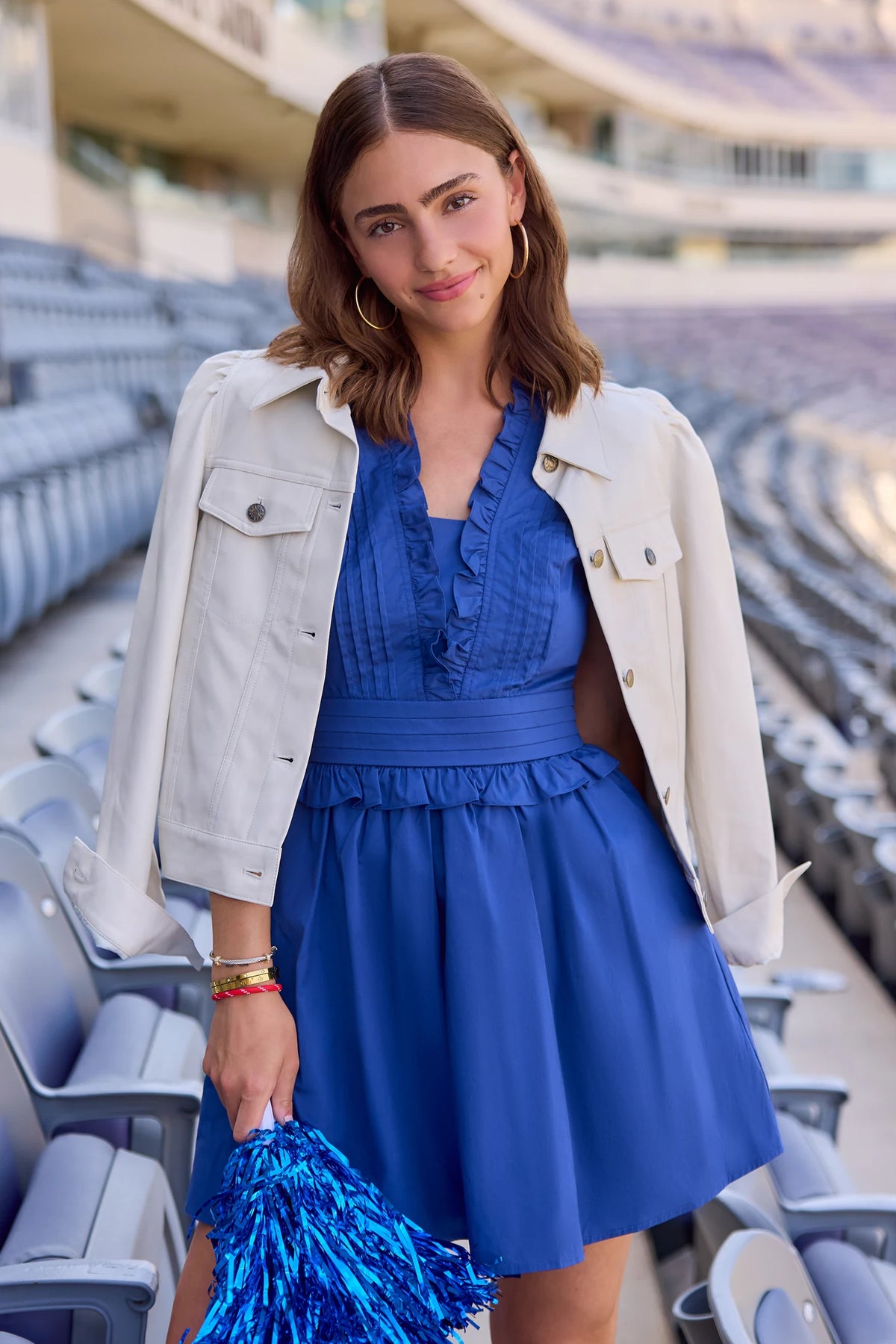 Makayla Blue Flutter Sleeve Short Dress styled with cream jacket at stadium, game day dress for women | Avara