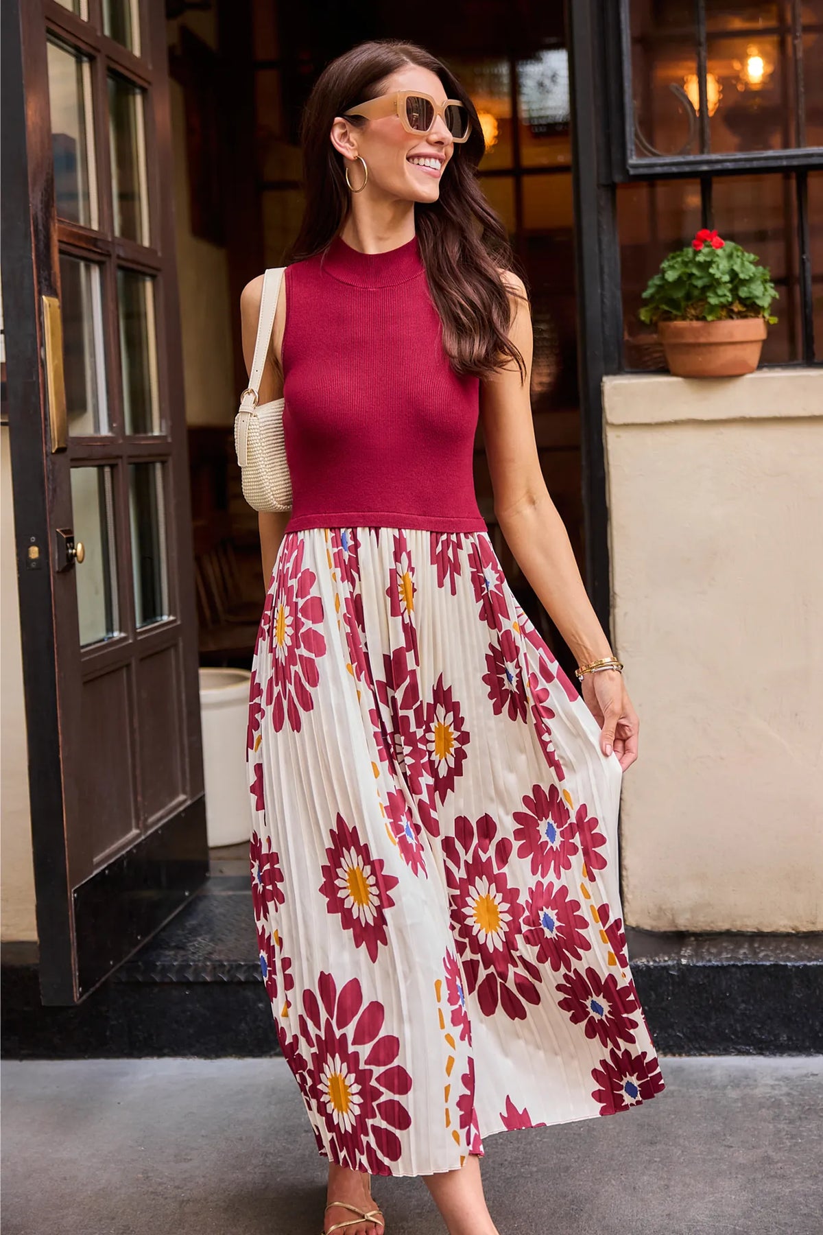 Woman in Marcia Burgundy Midi Dress styled with white bag, modest floral pleated skirt, city lifestyle | Avara