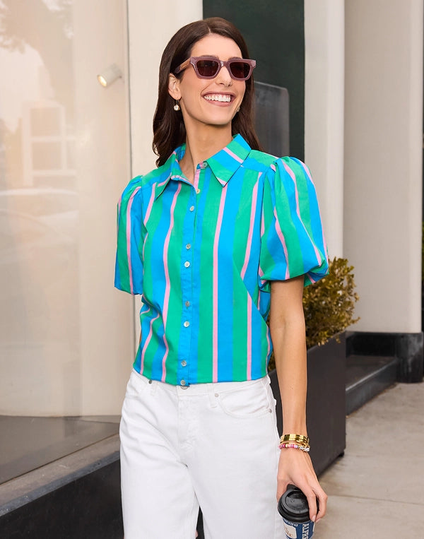 Woman wearing a colorful striped shirt and sunglasses, holding a coffee cup. navigation