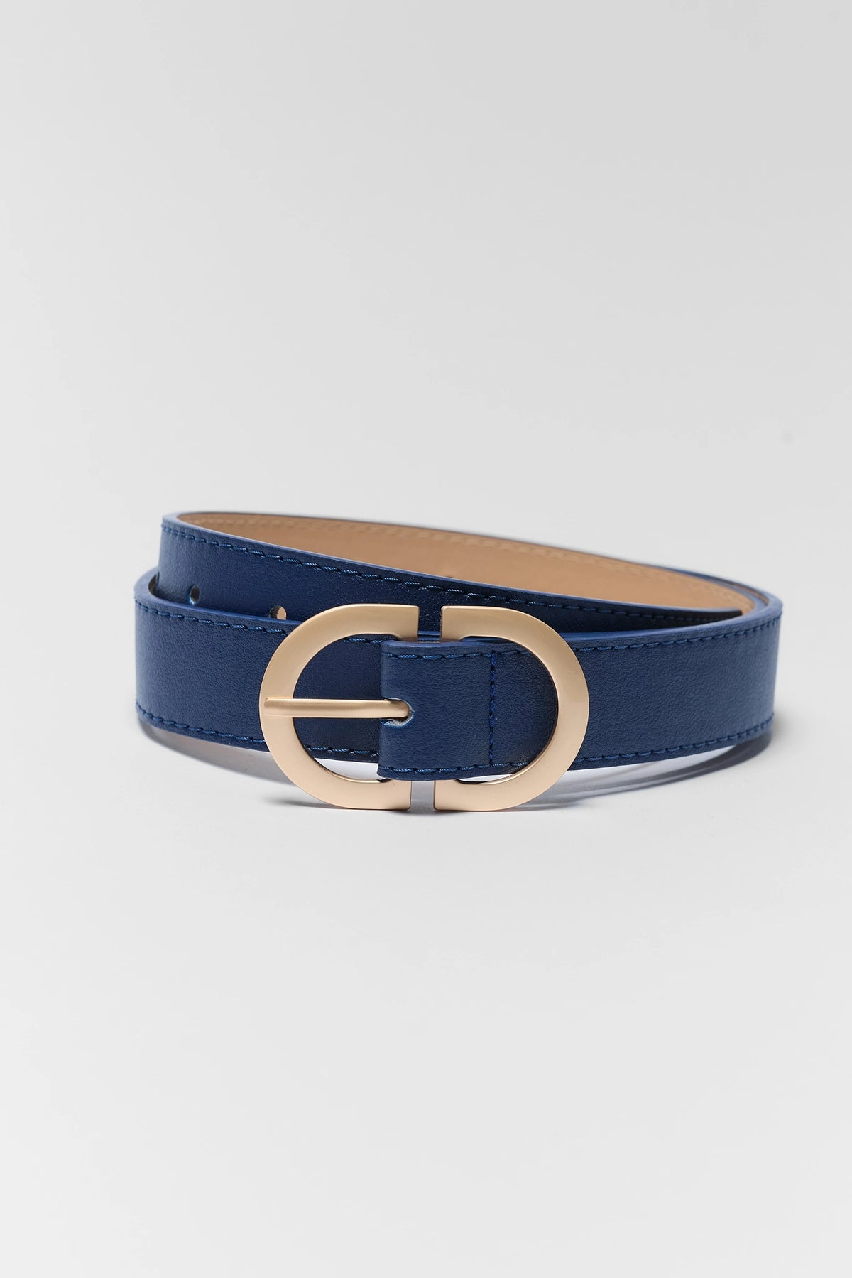 Navy blue faux leather belt coiled, gold-tone oval buckle - Angled View | Avara