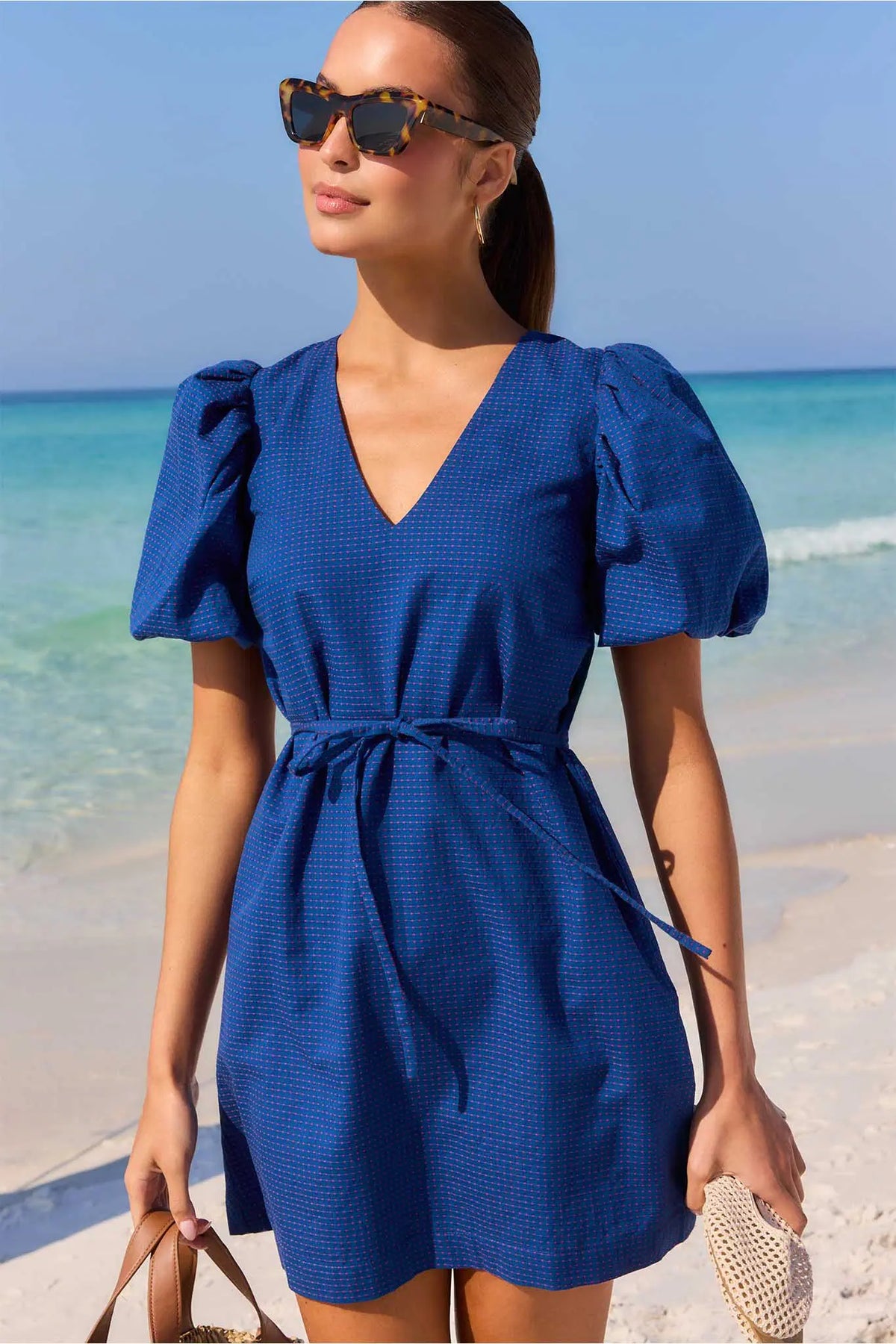 Navy embroidered dot puff sleeve short beach dress styled with sunglasses and rattan bag - Lifestyle | Avara