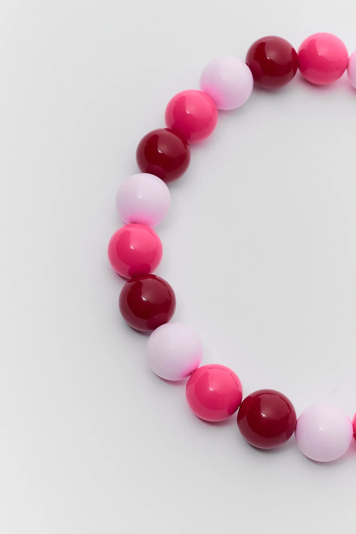 Close-up of chunky colorful beaded necklace showing glossy hot pink, magenta, and pale pink round beads - Bead Detail | Avara