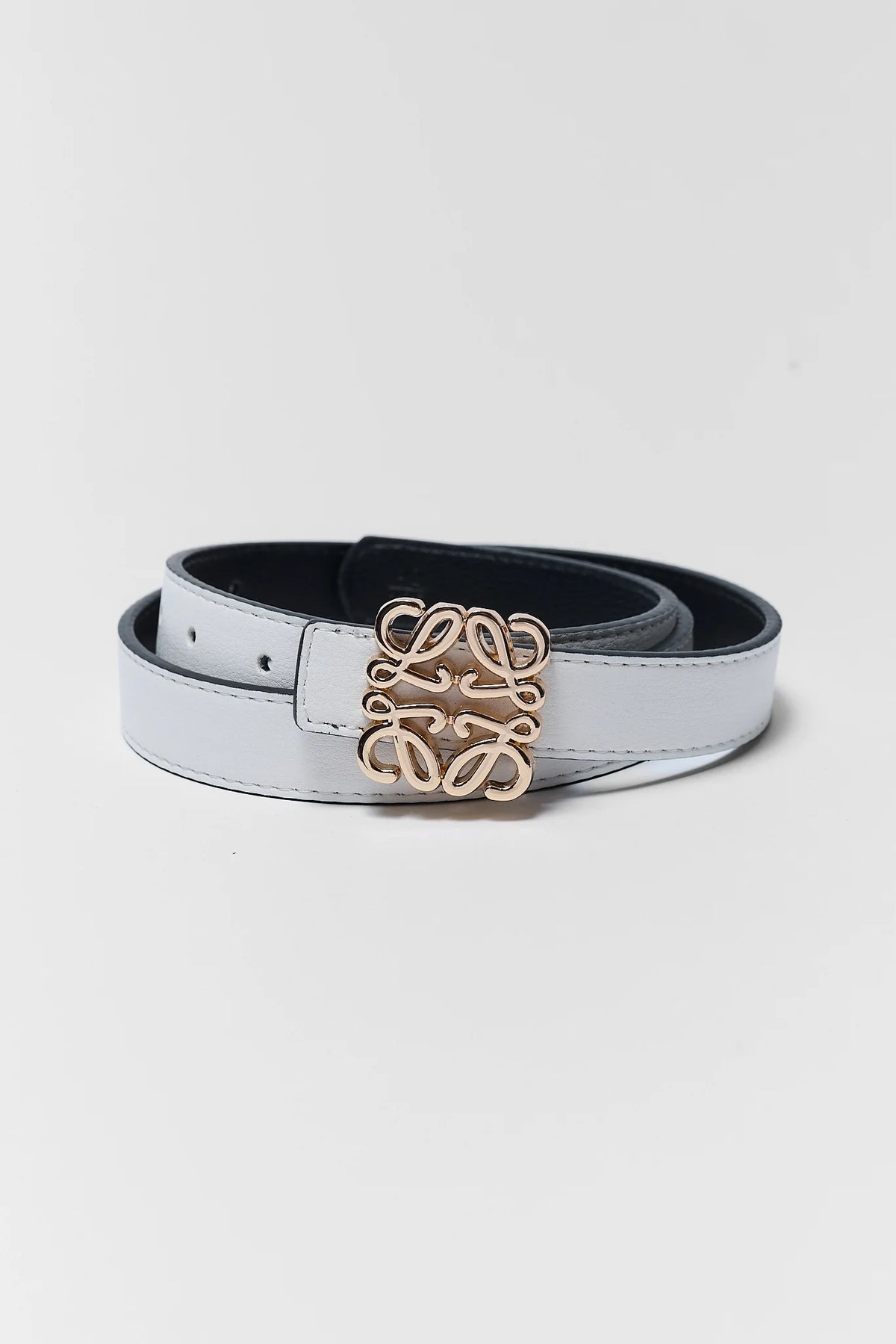 Rowan White Faux Leather Belt coiled, gold-tone monogram buckle, product flat lay | Avara