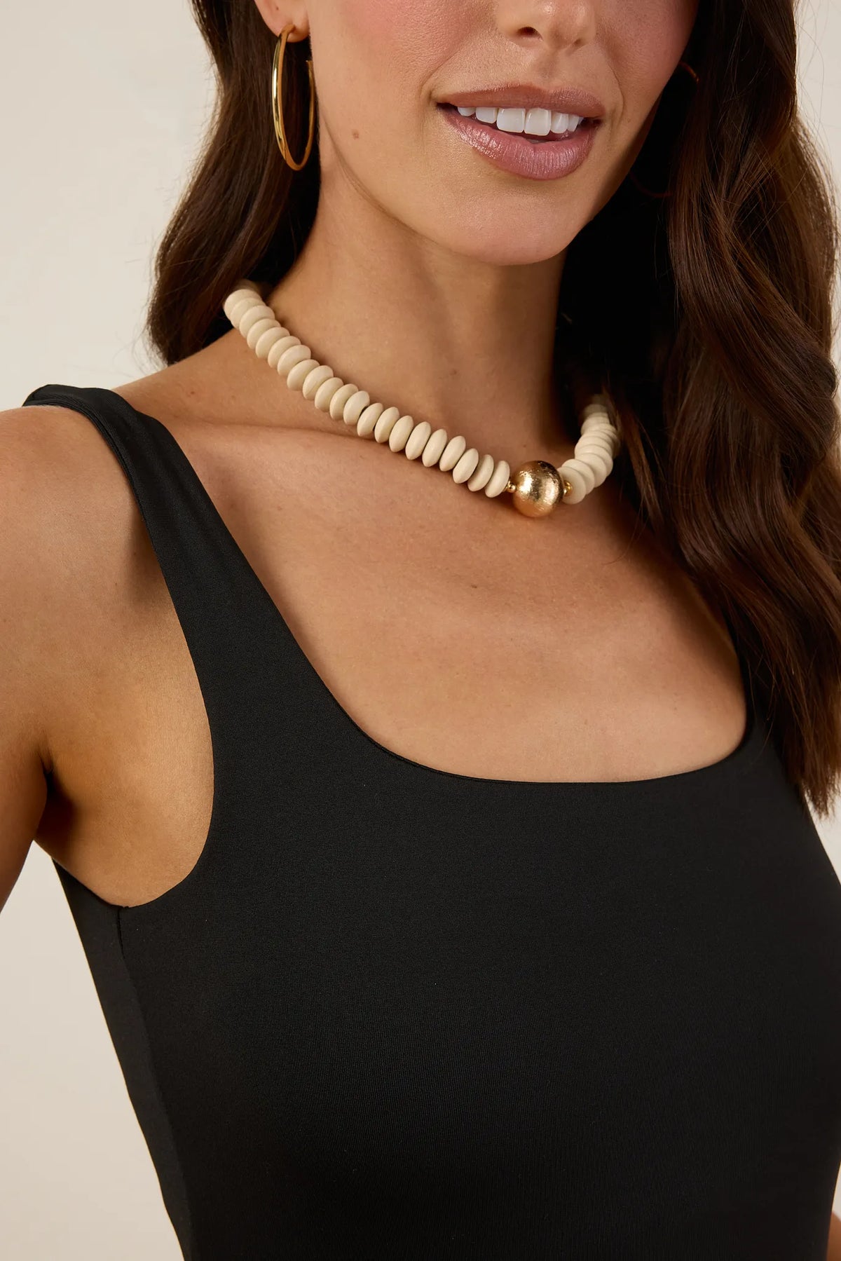 Bri Black Tank Bodysuit scoop neckline and wide strap detail, close-up with chunky bead necklace | Avara