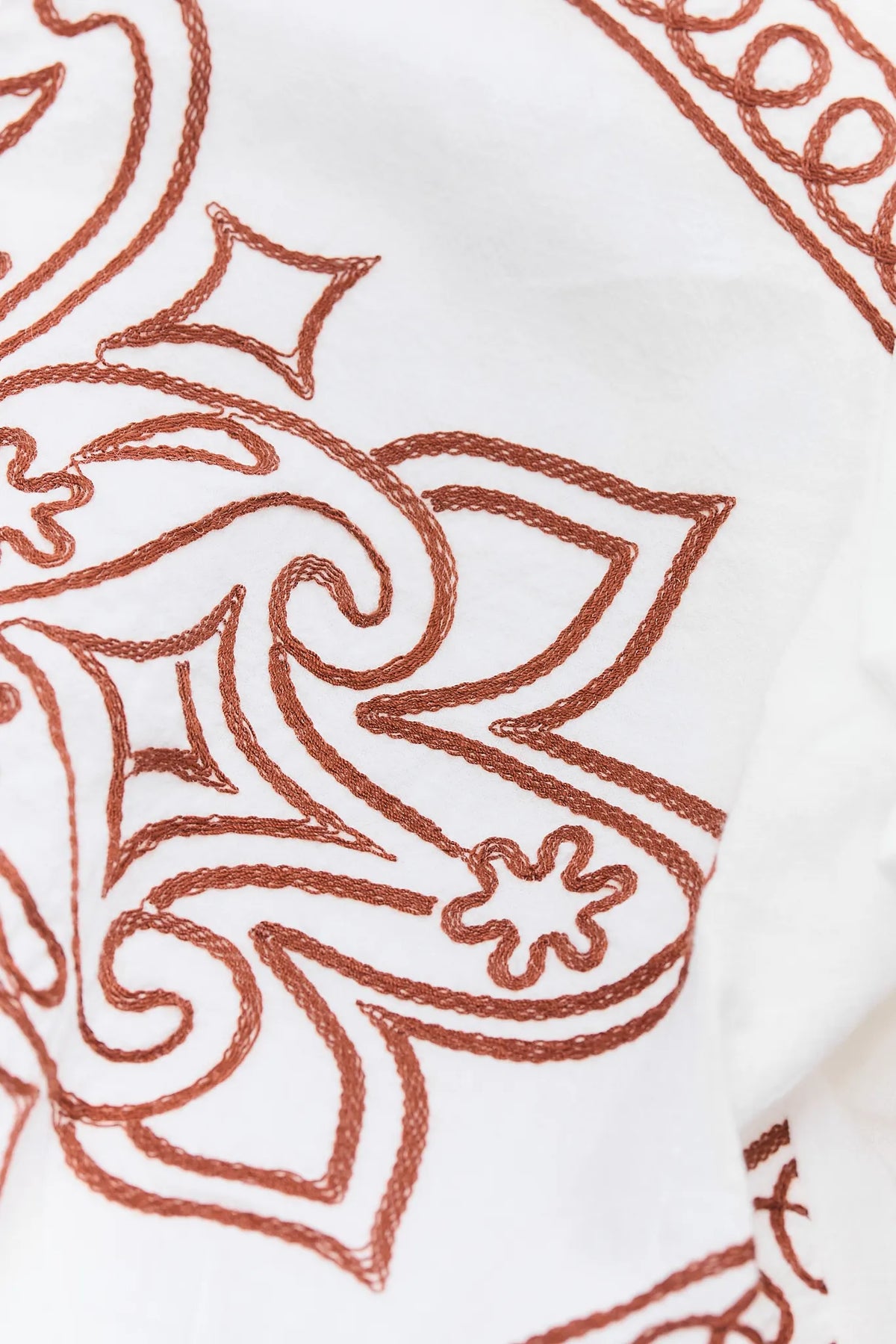 Brown Embroidery Thread Close-Up on Ivory Cotton Women's Top - Scrollwork Fabric Texture Detail | Avara