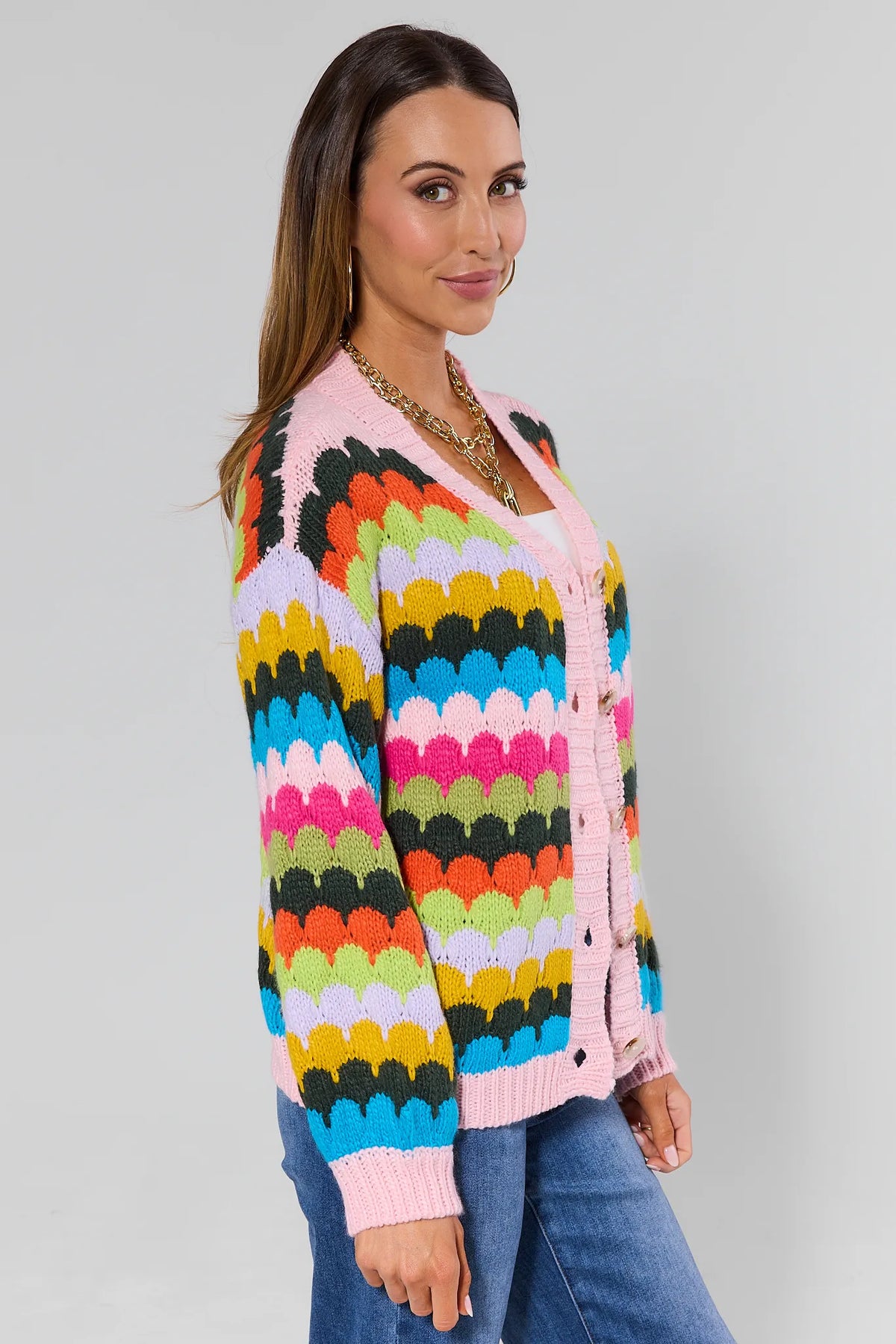 Woman wearing a colorful cardigan with a plain background
