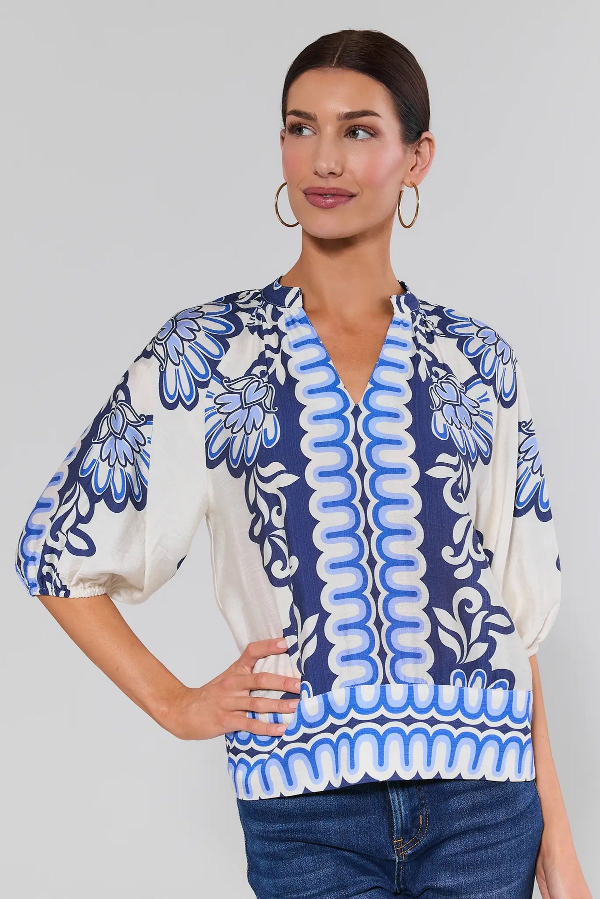 main shot Woman wearing a blue and white patterned blouse with a plain background