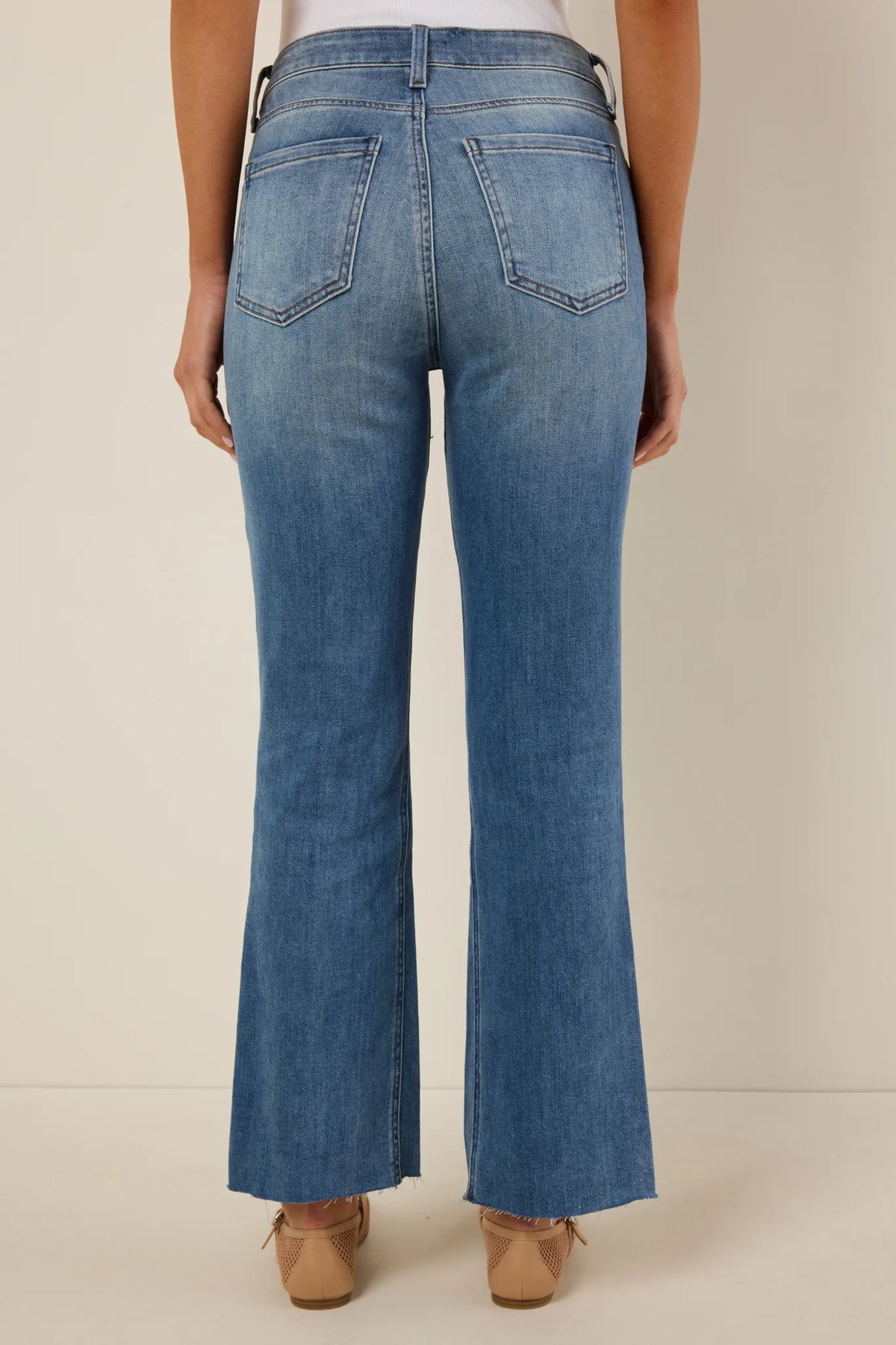 Kelsey Light Wash Kick Flare Jeans by KUT - Back Detail showing flare silhouette, raw split hem, and back pockets | Avara