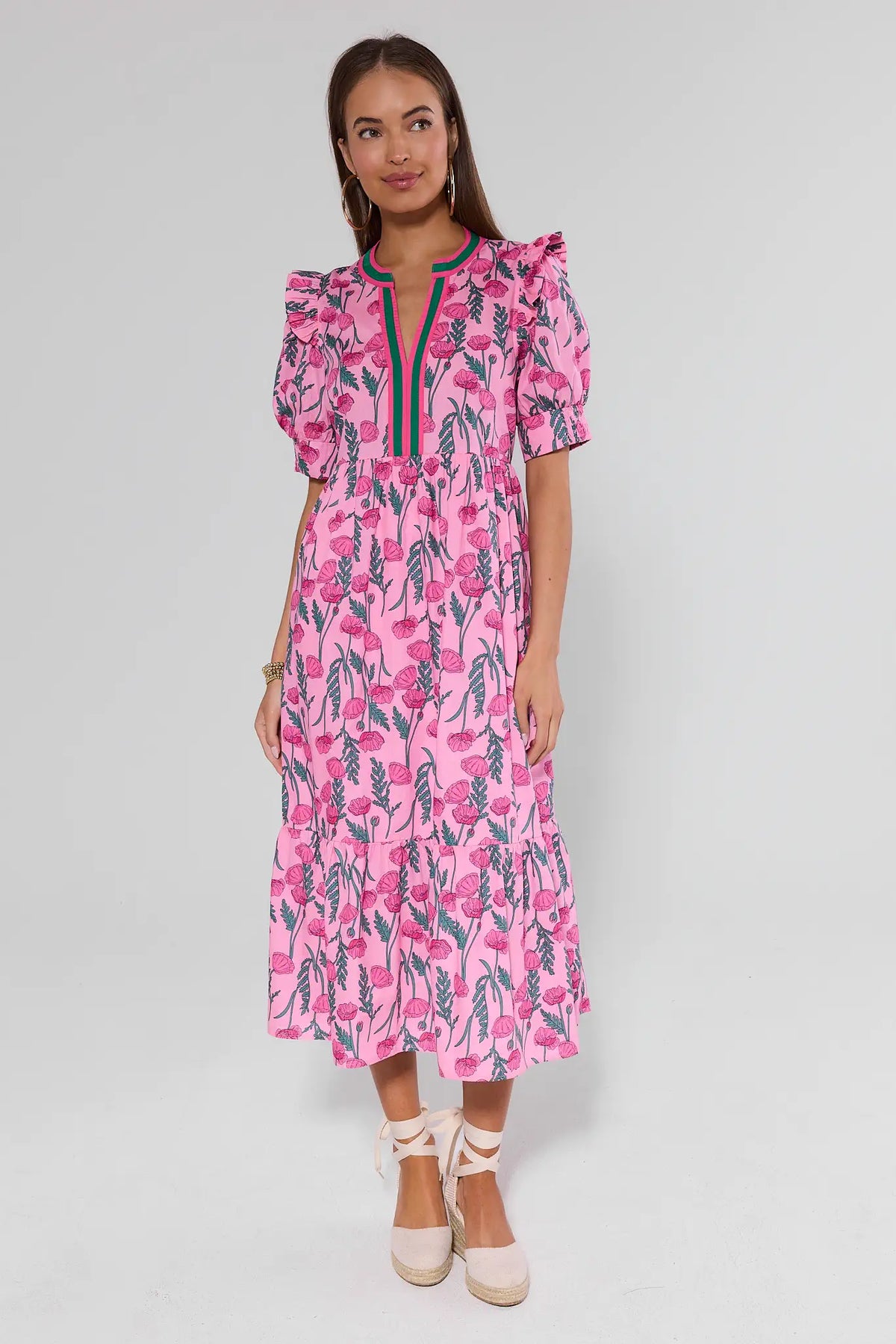 Woman wearing a pink floral dress on a light background