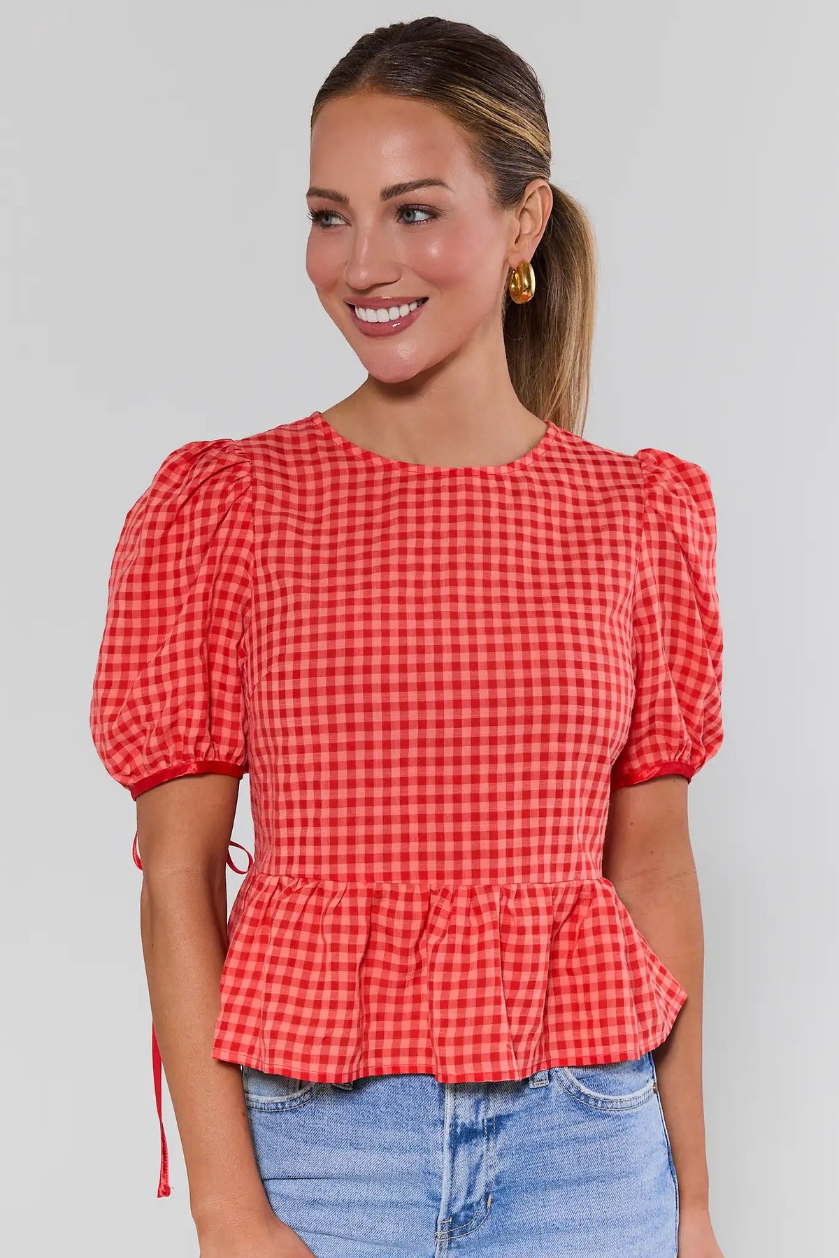 Felicia Red Gingham Peplum Top front view with puff sleeves, styled with light wash jeans | Avara