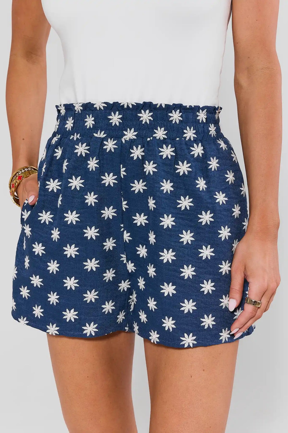 Navy chambray floral embroidered shorts with ruffle waist, close-up front detail | Avara
