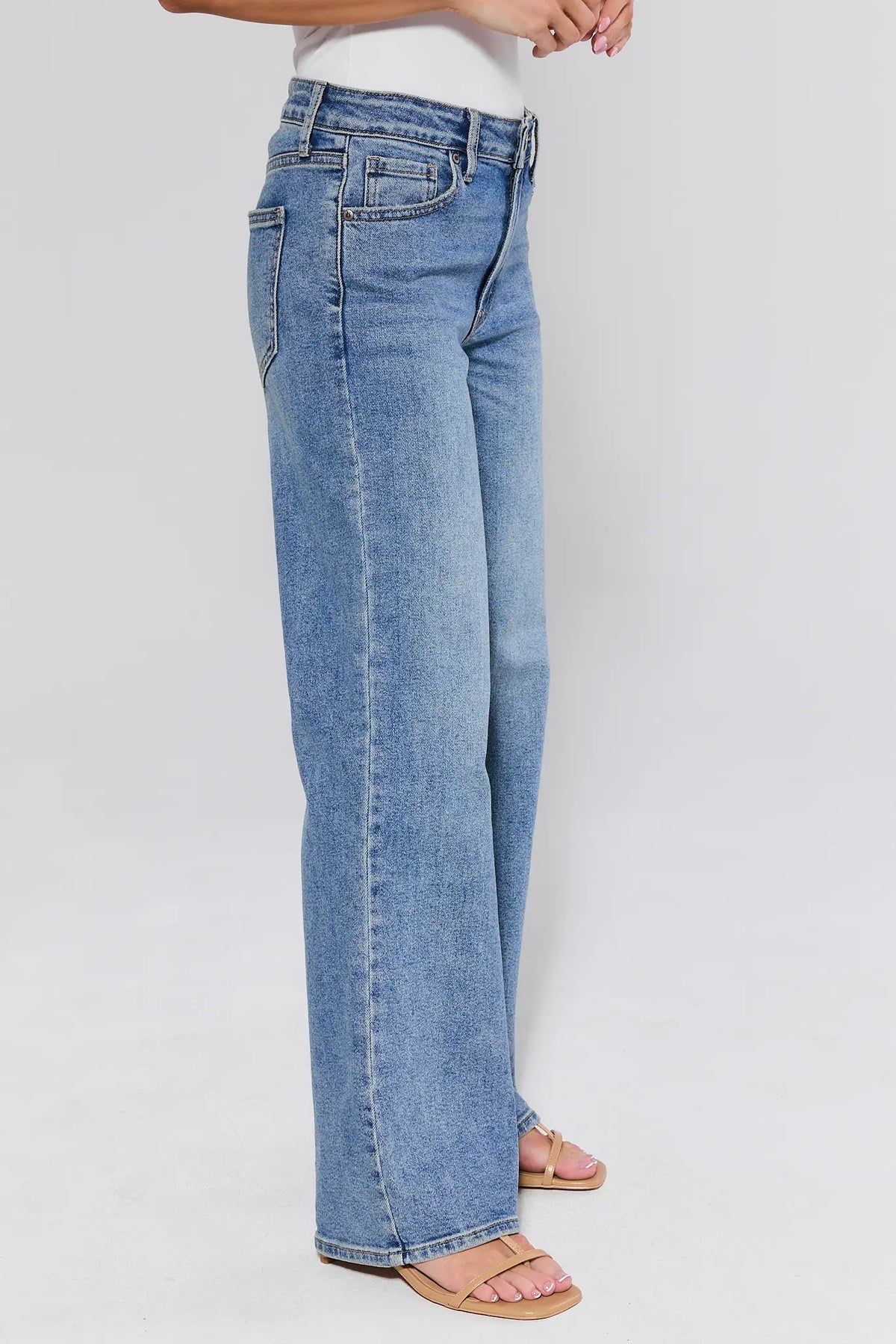 Light blue jeans worn by a person on a plain background