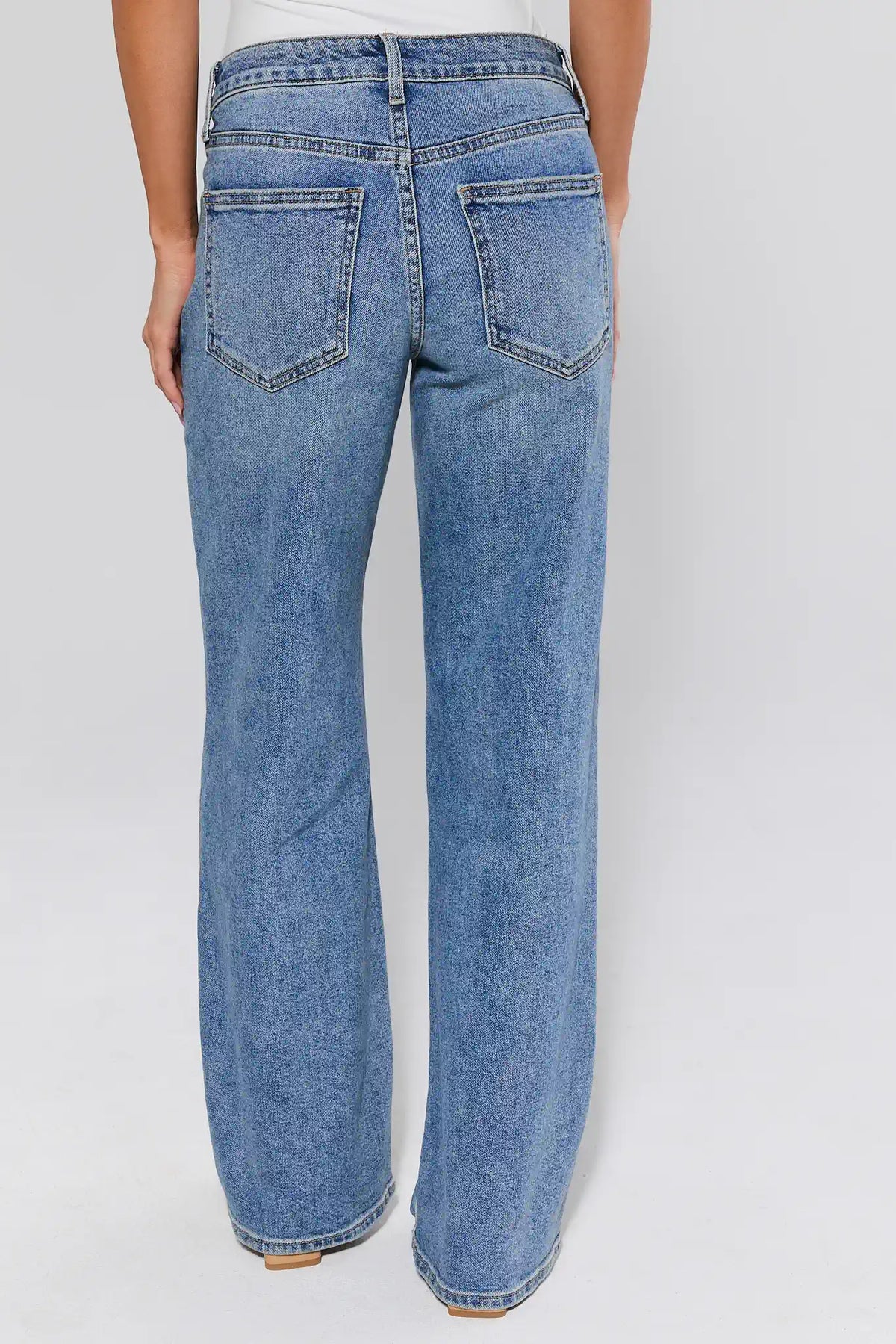 Blue jeans worn by a person on a white background