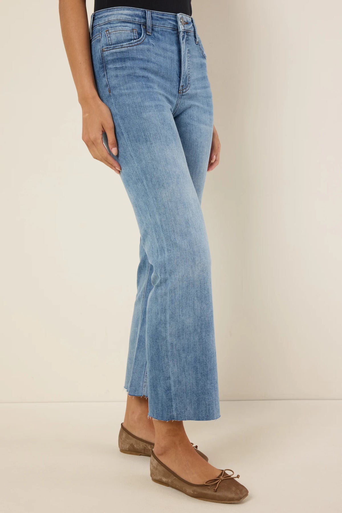 Kelsey Medium Wash Kick Flare Jeans - Side View, inset flare panel and raw frayed hem detail | Avara