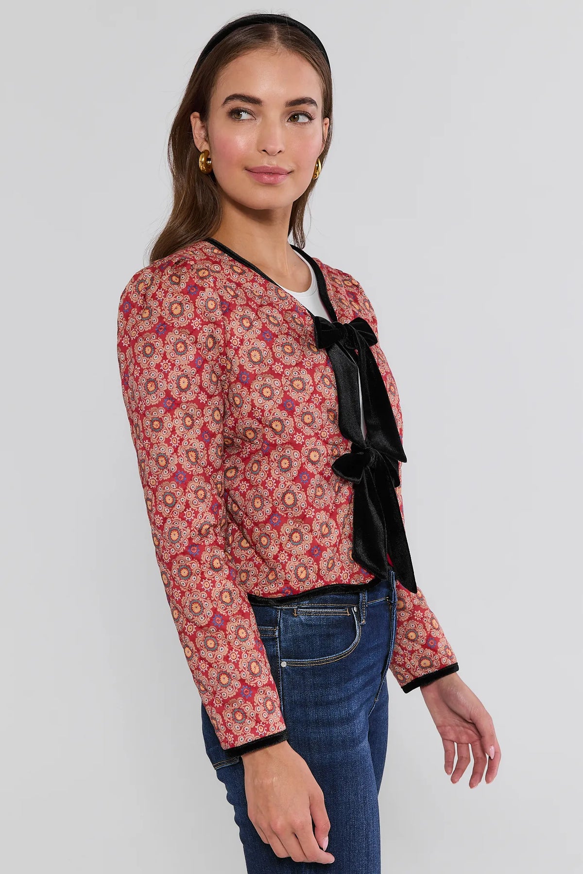 Ember Printed Bow Jacket red medallion quilted print with black velvet trim and bows, side profile view styled with denim jeans | Avara