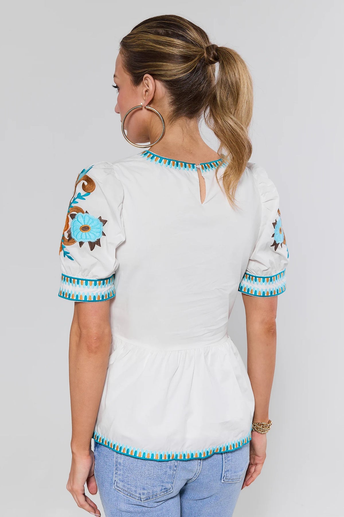 White Floral Embroidered Peplum Top - Back View with Keyhole Neckline Detail | Avara