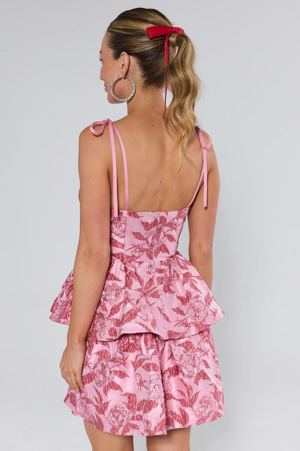 Pink Metallic Brocade Mini Dress with Tiered Ruffle Skirt - Back View with Tie Strap Detail | Avara