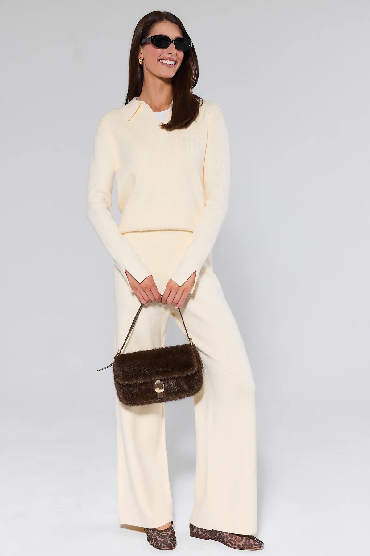 Elle Ivory Knit Pants and matching sweater set styled with sunglasses and faux-fur bag — Full Length View | Avara