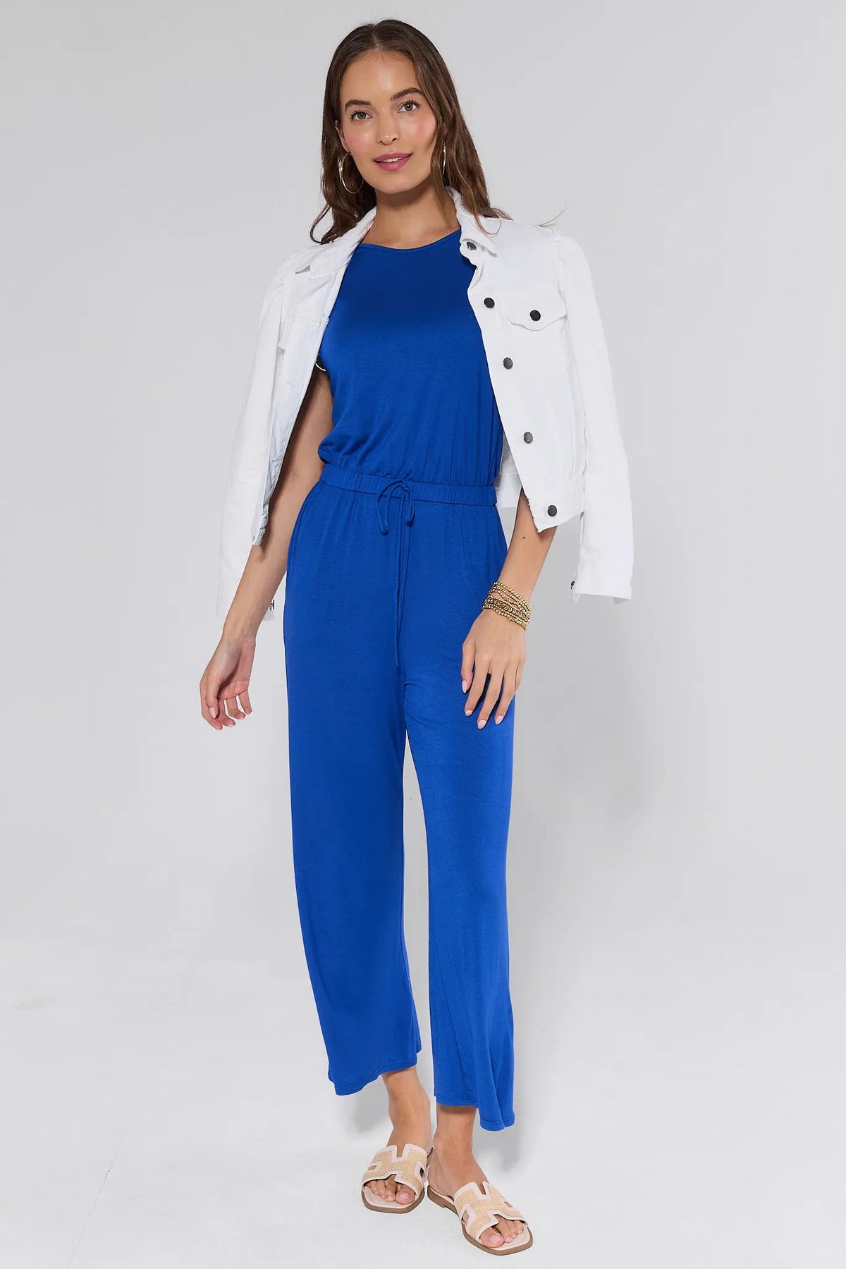 Heidi Blue Wide Leg Jumpsuit styled with white jacket and sandals - Full Front View | Avara