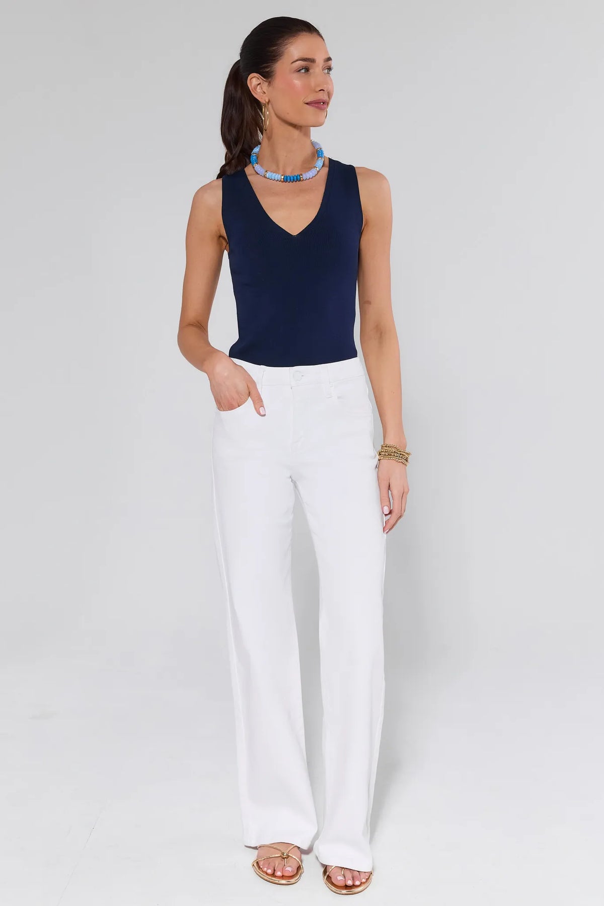 Woman in Navy Sleeveless Top and White Straight Leg Jeans Full Length On Model | Avara