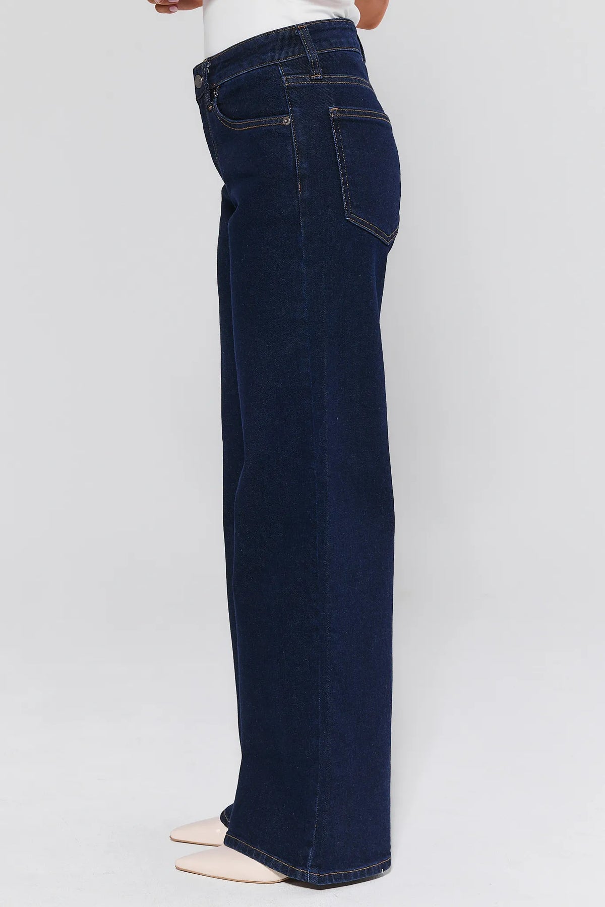 Dark blue jeans worn by a person on a light gray background