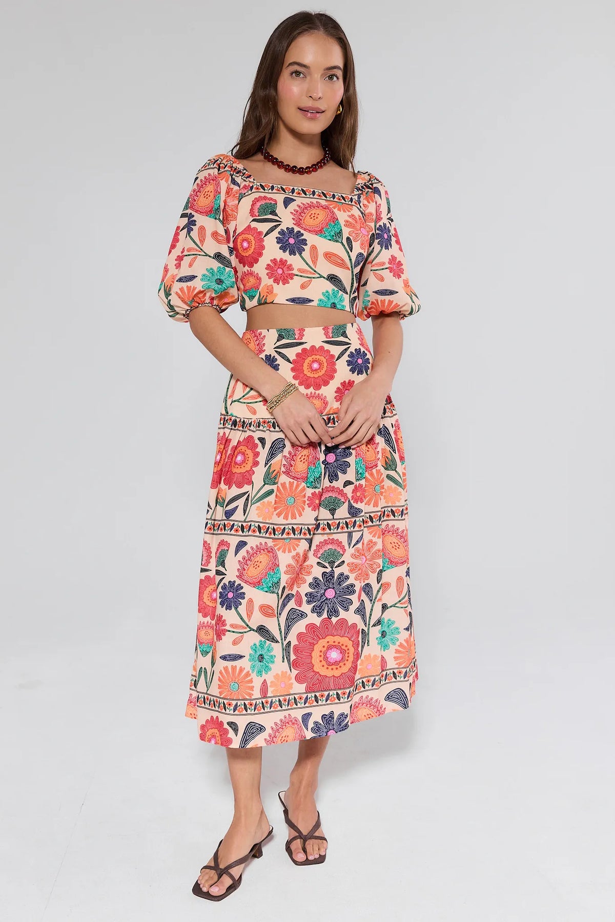 Woman wearing a colorful floral dress on a white background