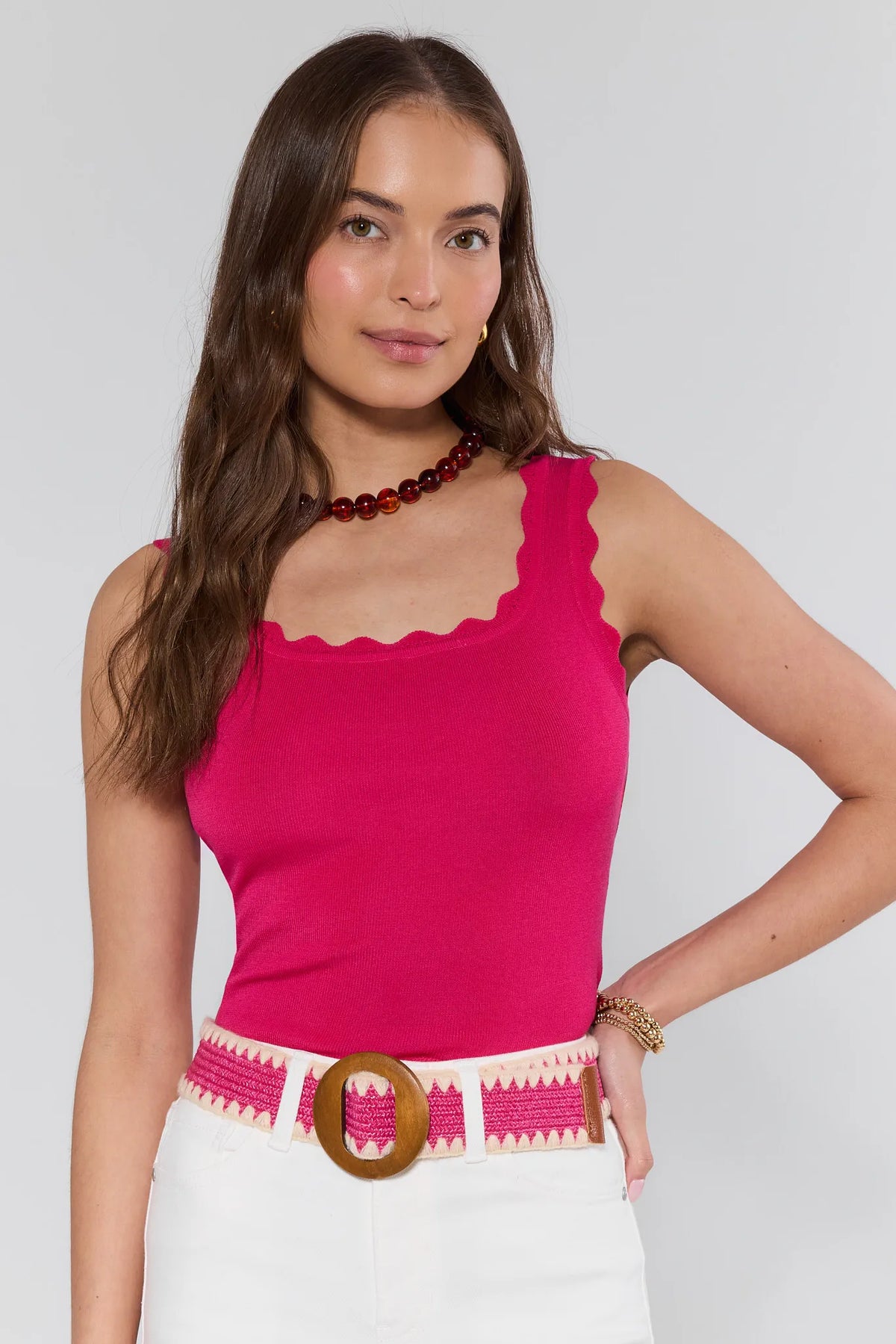 Pink ribbed-knit scalloped tank top styled with white pants and woven belt - Front View | Avara