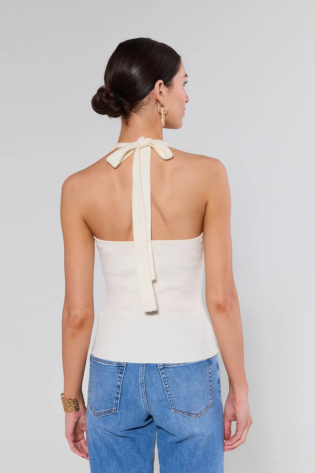 Meg Ivory Knit Halter Top back view, ribbed open-back design with tie closure, paired with blue jeans | Avara
