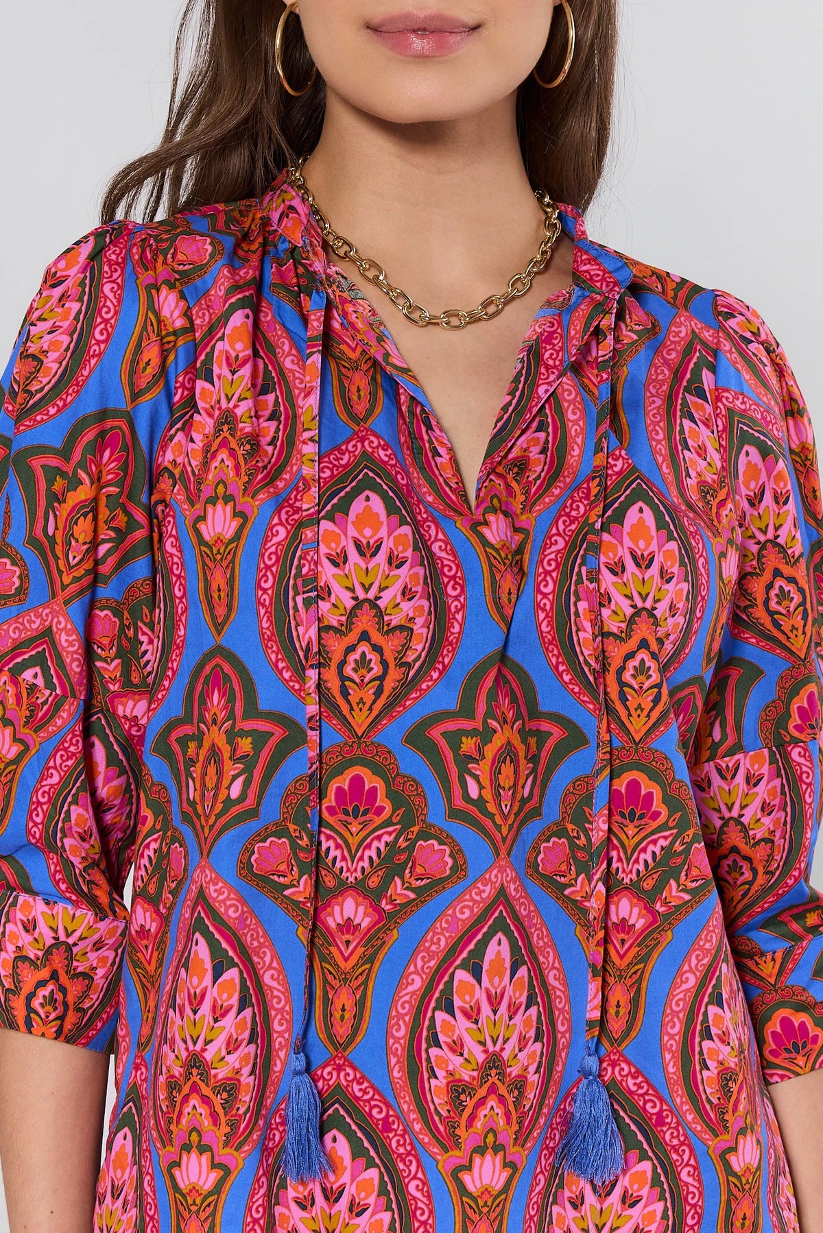 Woman wearing a colorful patterned dress with a white background
