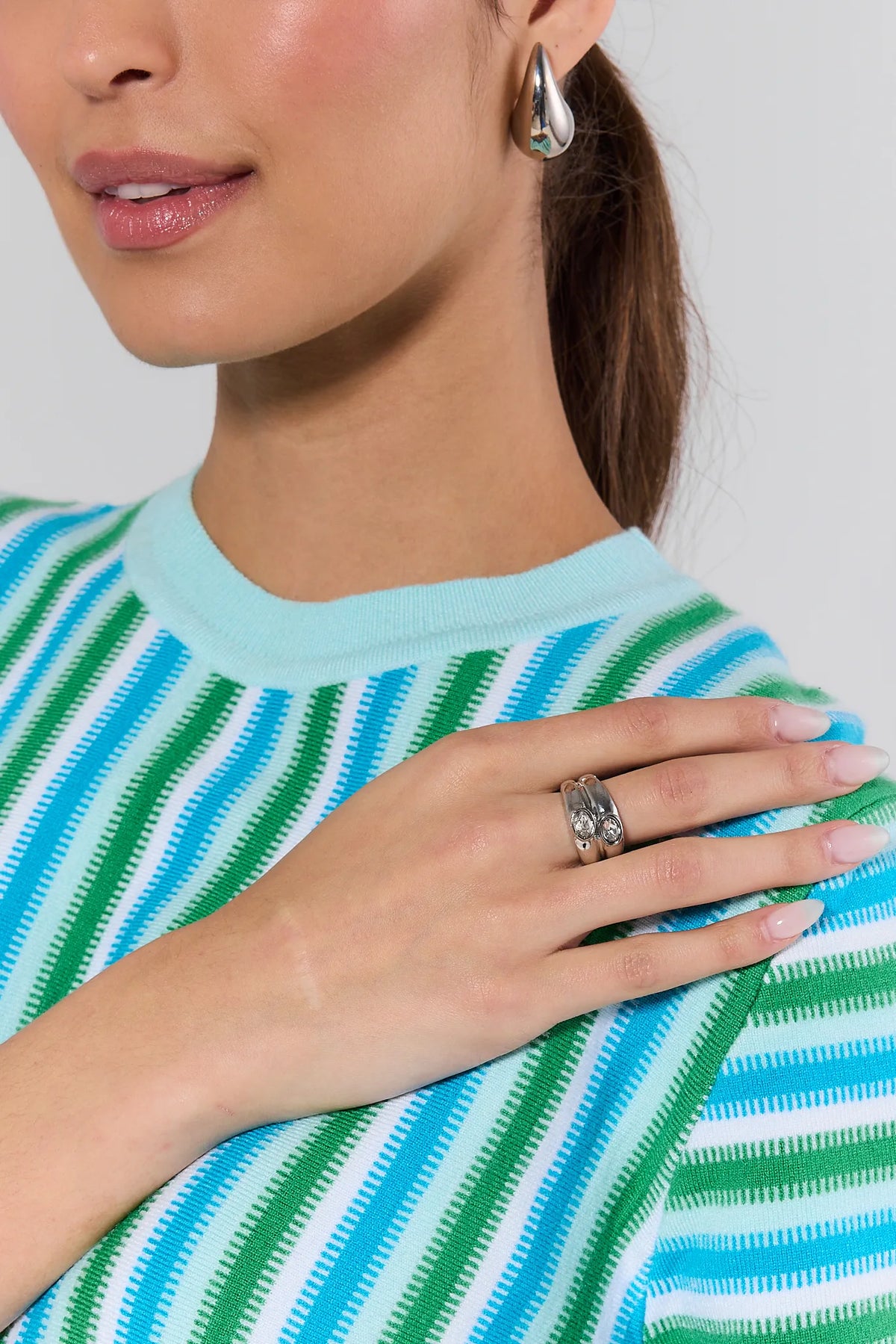 Nelly Silver Rhinestone Ring worn on model's finger, styled with striped top - On Model Detail | Avara