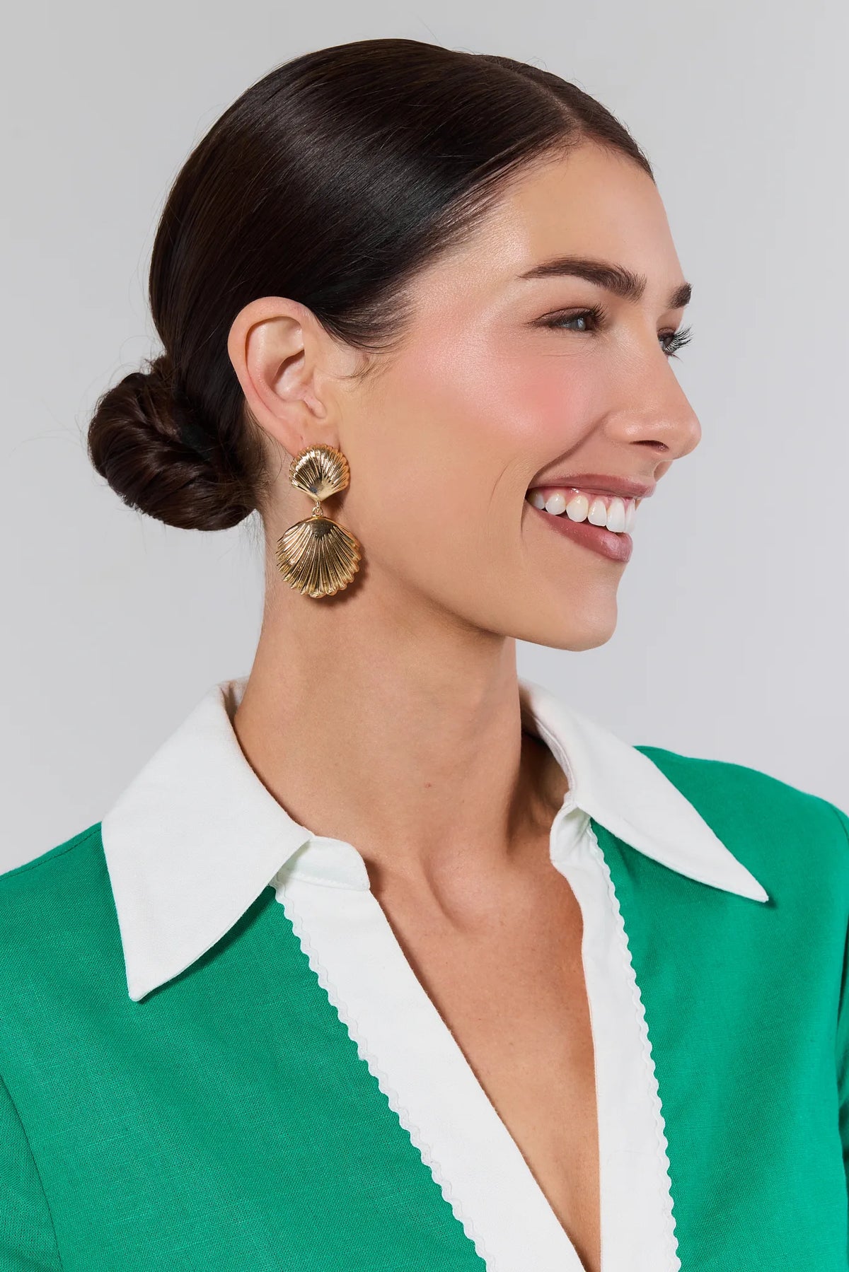 Woman wearing Kaia Gold Shell Drop Earrings styled with green top - Side Profile | Avara