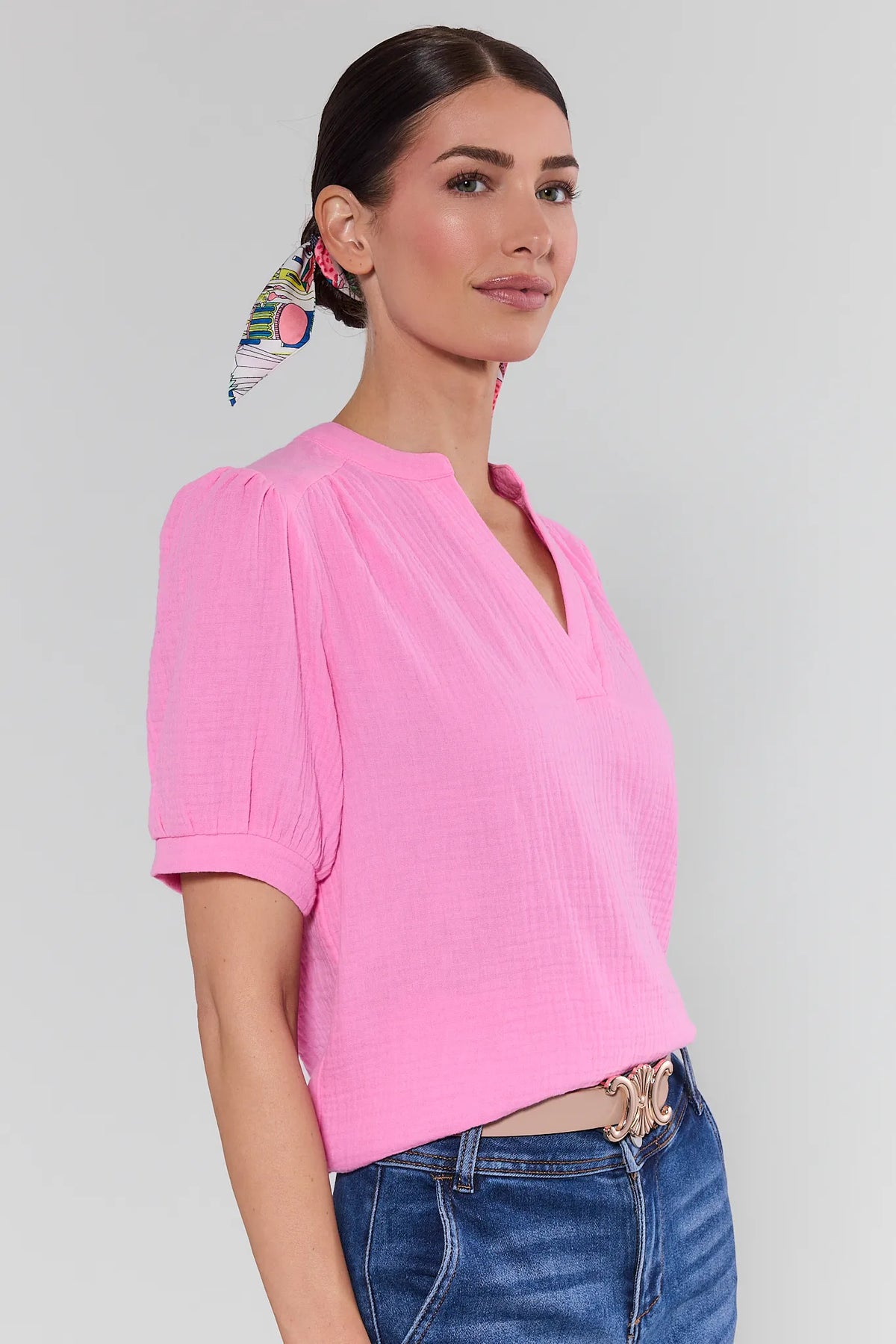 View 4: Woman wearing a pink blouse and blue jeans against a plain background