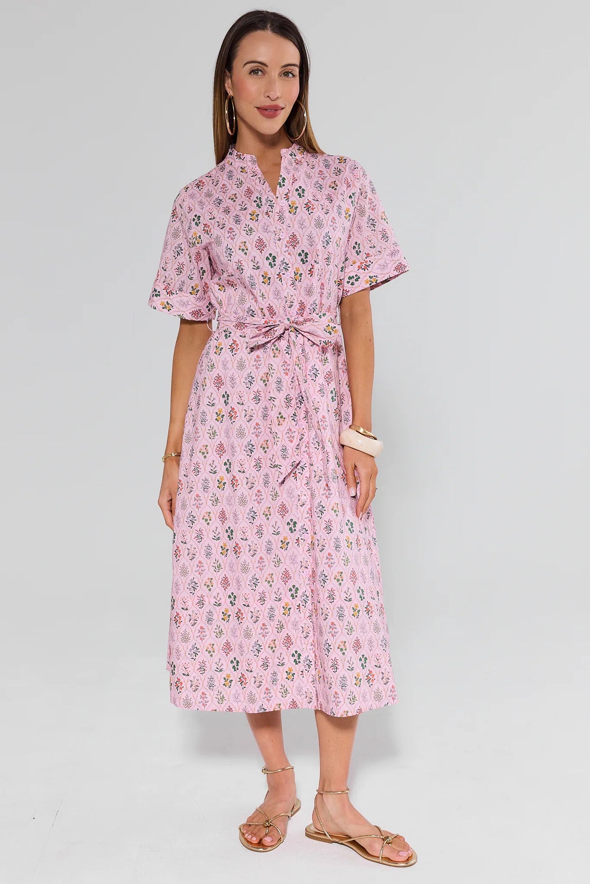 Woman wearing a pink floral dress on a white background