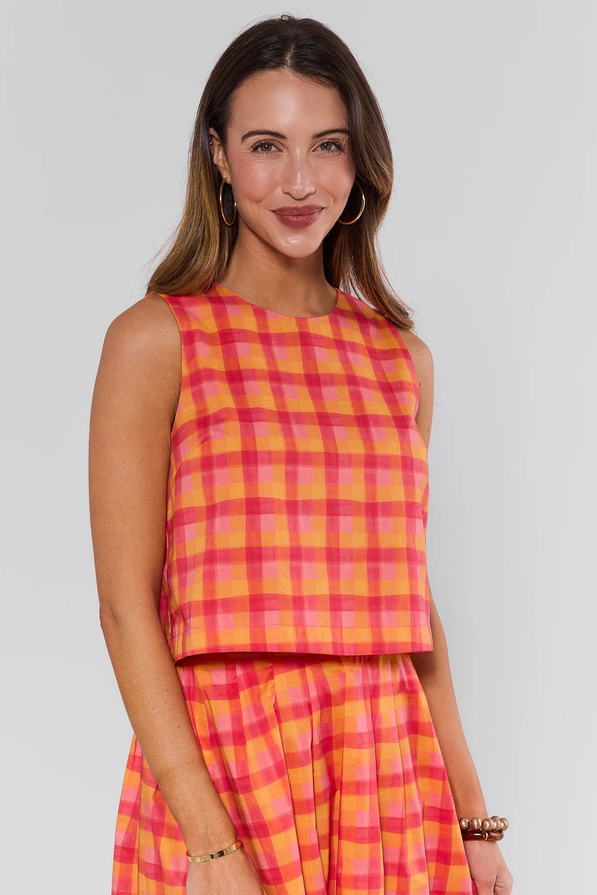 Orange pink plaid boxy tank top on model, angled front view, styled with matching skirt | Avara